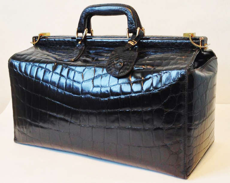A fine and rare vintage Bijan travel case. Exquisite Prorsus crocodile skins, 1 of 5 cases produced 1988. Supple jet black skins item features gilt metal hardare and glides. Item fully lined in a grey leather with two open interior pockets. Rare