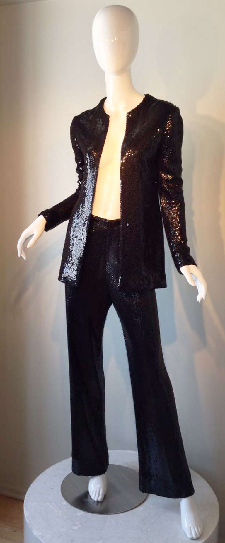 A fine and rare vintage Halston sequin trouser suit. Iconic jet black silk jersey items completely covered in black sequins. Jacket features a open front (no closures). Matching trousers feature a elastic waist and side zipper. Pristine appears