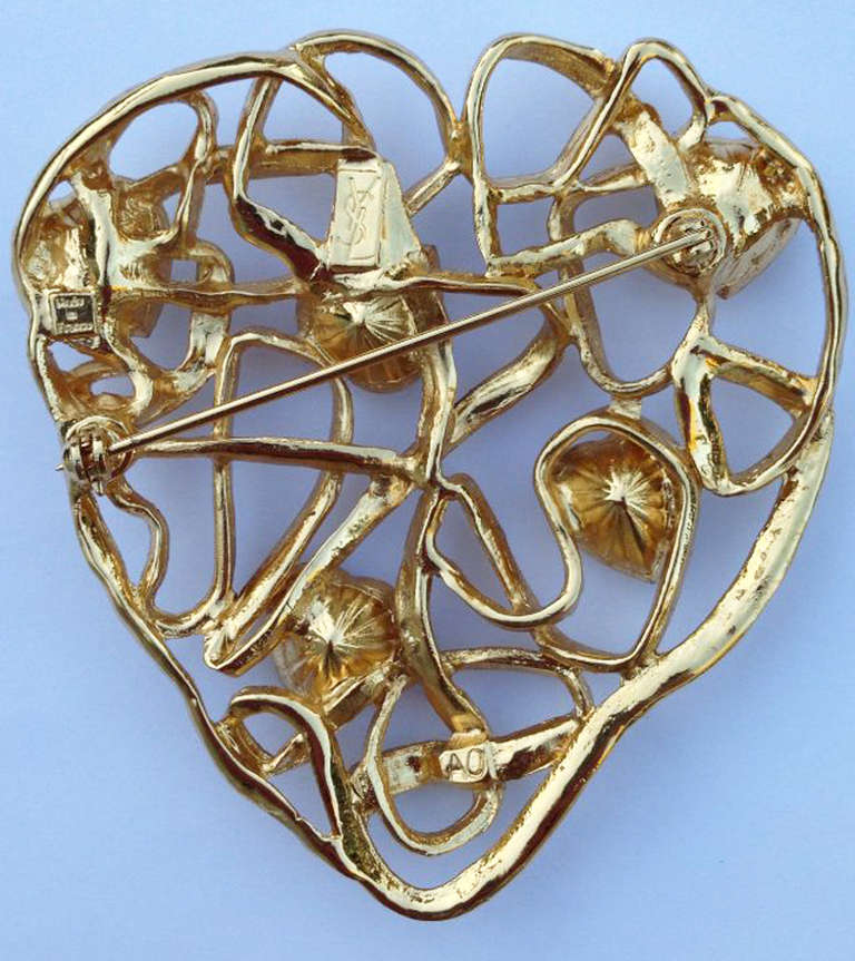 A fine vintage Yves Saint Laurent heart brooch. Openwork gilt metal tem features 