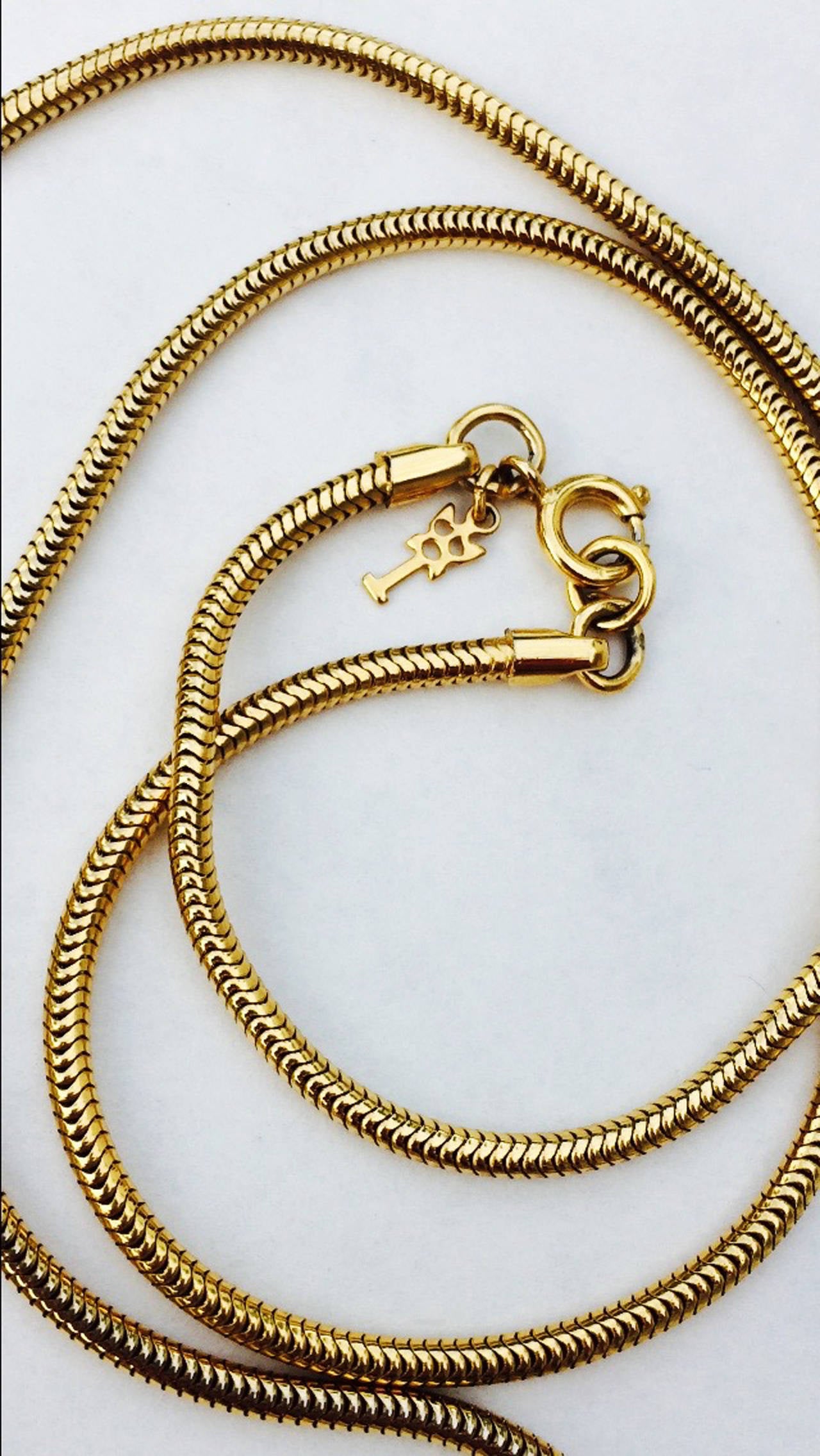 A fine vintage Trifari necklace in the American modernist style. Signed gilt snake link chain suspends a sculpted white enamel metal panel with a additional gilt metal overlay. Original locking ring closure intact. Excellent possibly unworn.