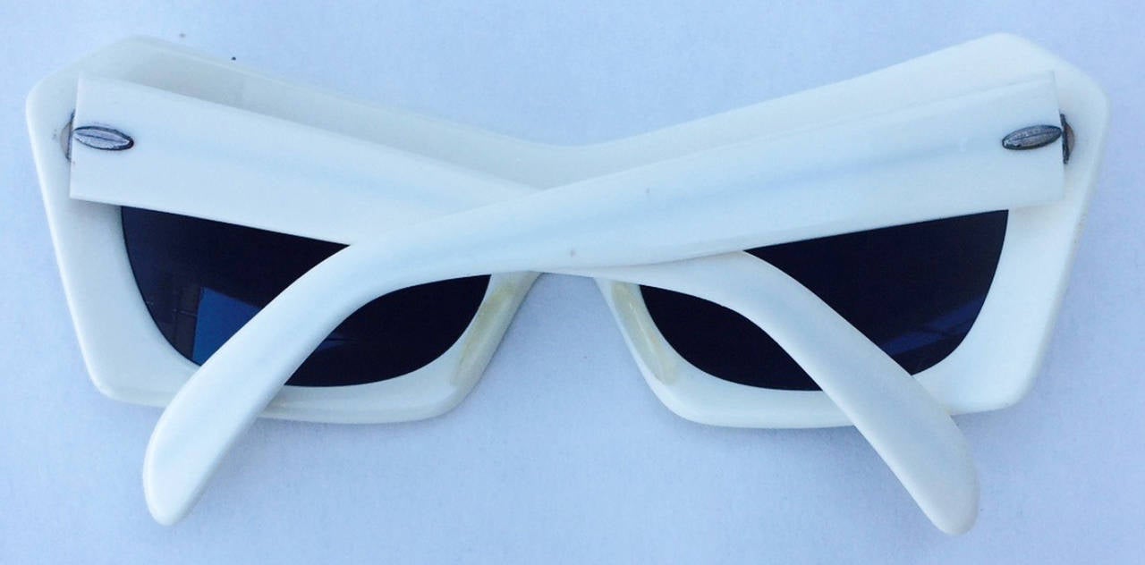 A fine vintage pair ladies sunglasses. Signed thick white plastic frames with original tinted glass lenses intact. These are for a petite/small sized head. Pristine appear unworn.