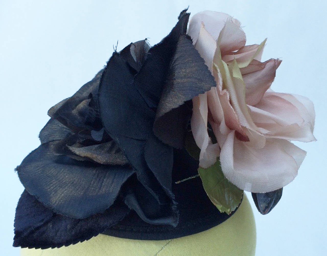A fine vintage Don Marshall floral Fascinator hat. Authentic silk item features a pair of large contrasting silk flower heads atop a black silk cap. Item additionally features silk ribbon trim with a hair pin and combs. Pristine possibly unworn.