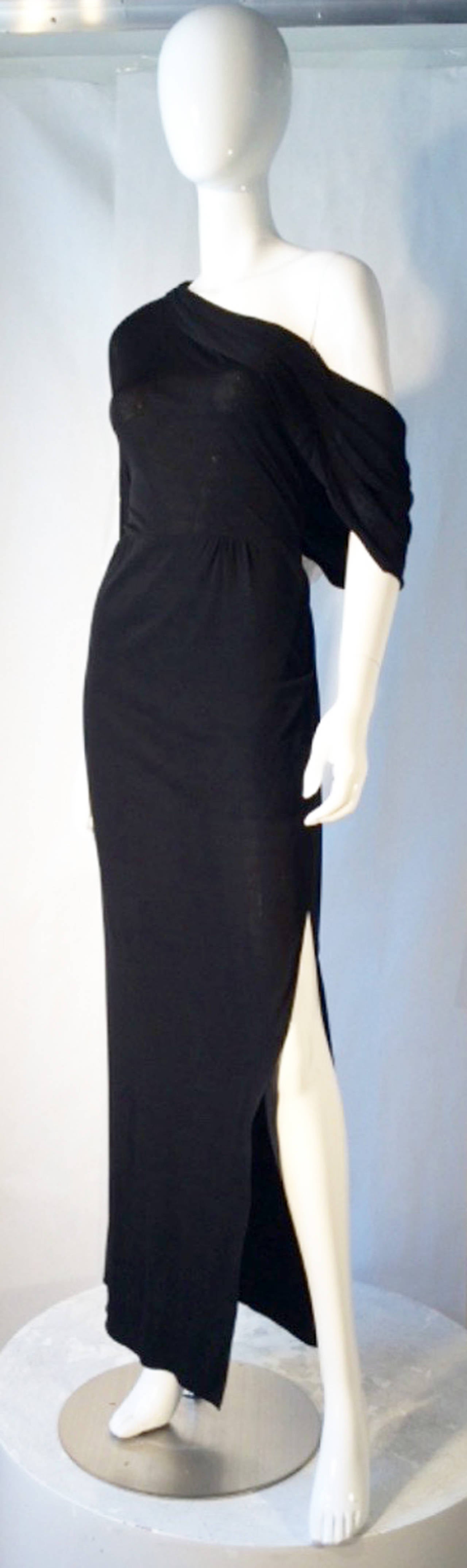 A exquisite vintage John Anthony couture jersey evening gown. Seductive  one-off item features a single arm sleeve and draping over opposite open shoulder. Nipped waist item with a full off center front leg vent and back zipper. Pristine appears