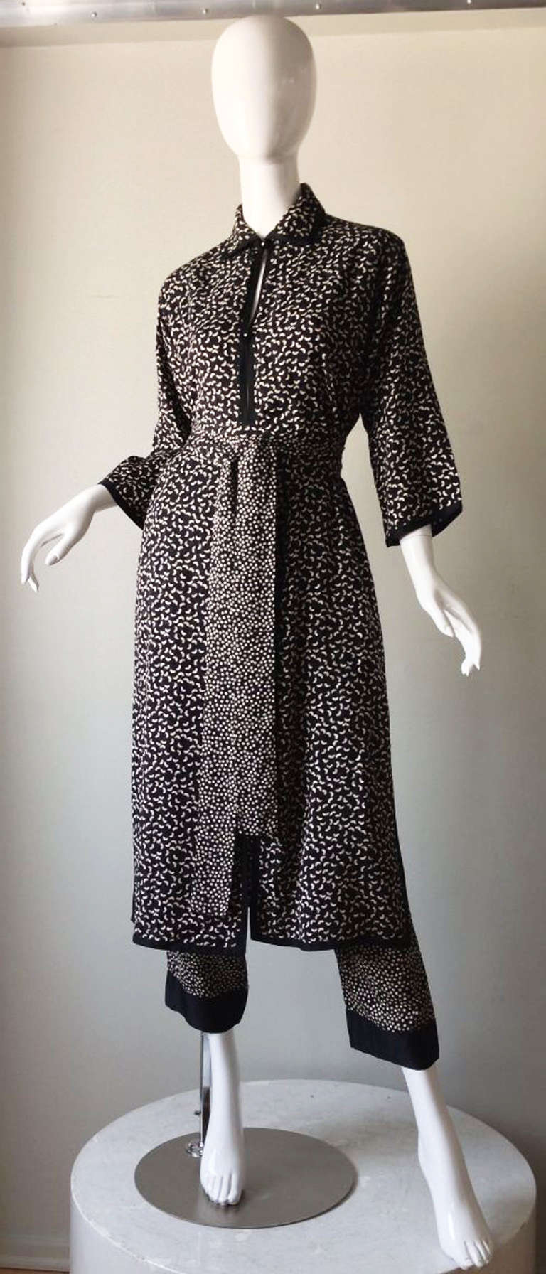 A fine and rare vintage Yves Saint Laurent haute couture ensemble. Fine white on black silk jacquard print fabric items include a tunic (button front) and trousers and matching sash belt. Pristine.
