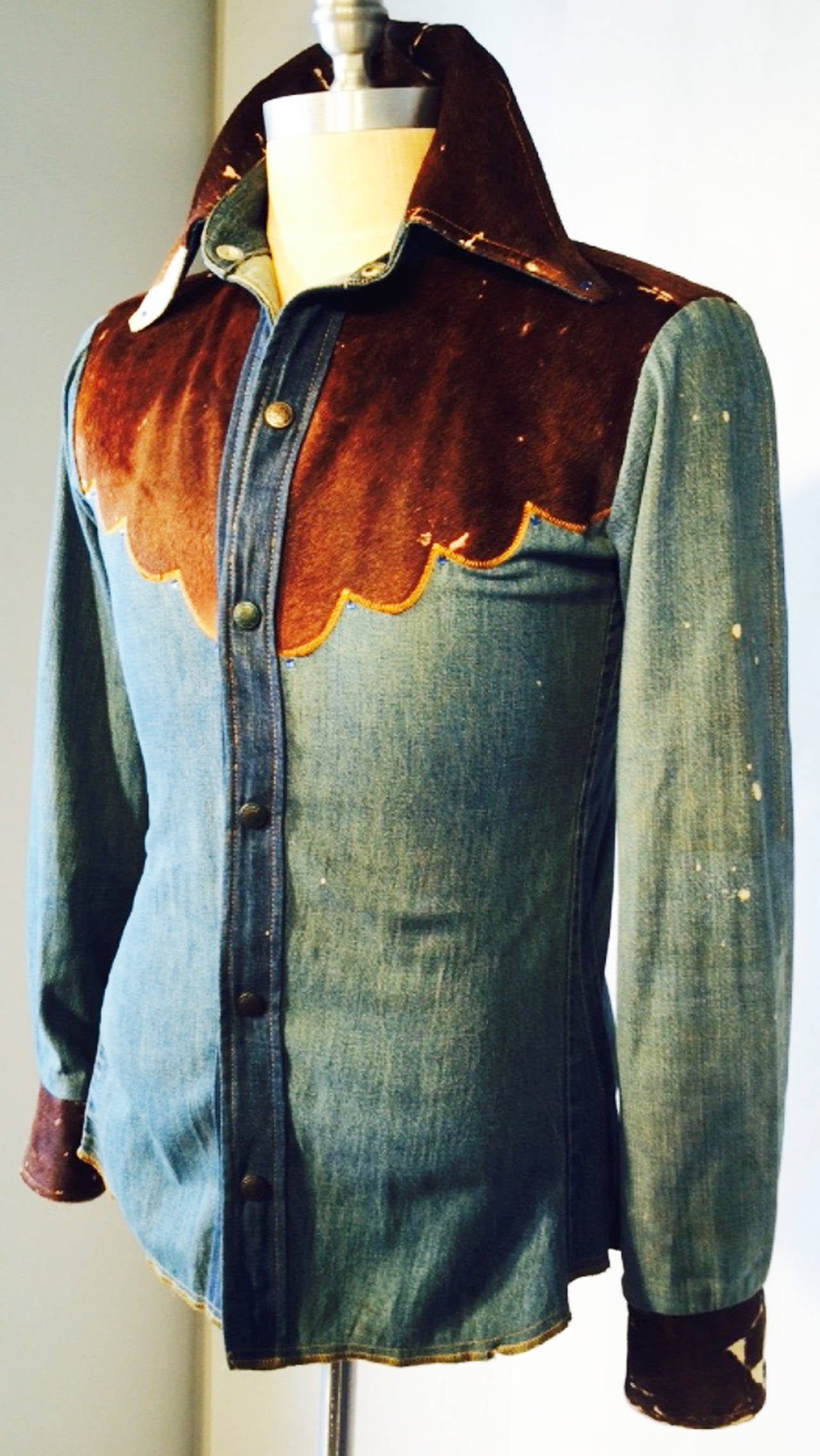 A fine and rare vintage gents Antonio Guiseppe embellished denim jacket/shirt. Authentic two-tone denim item trimmed in cowhide and crystals with metal snap front and cuff closures. A rare period rock and roll musician costume/stage item. Excellent.