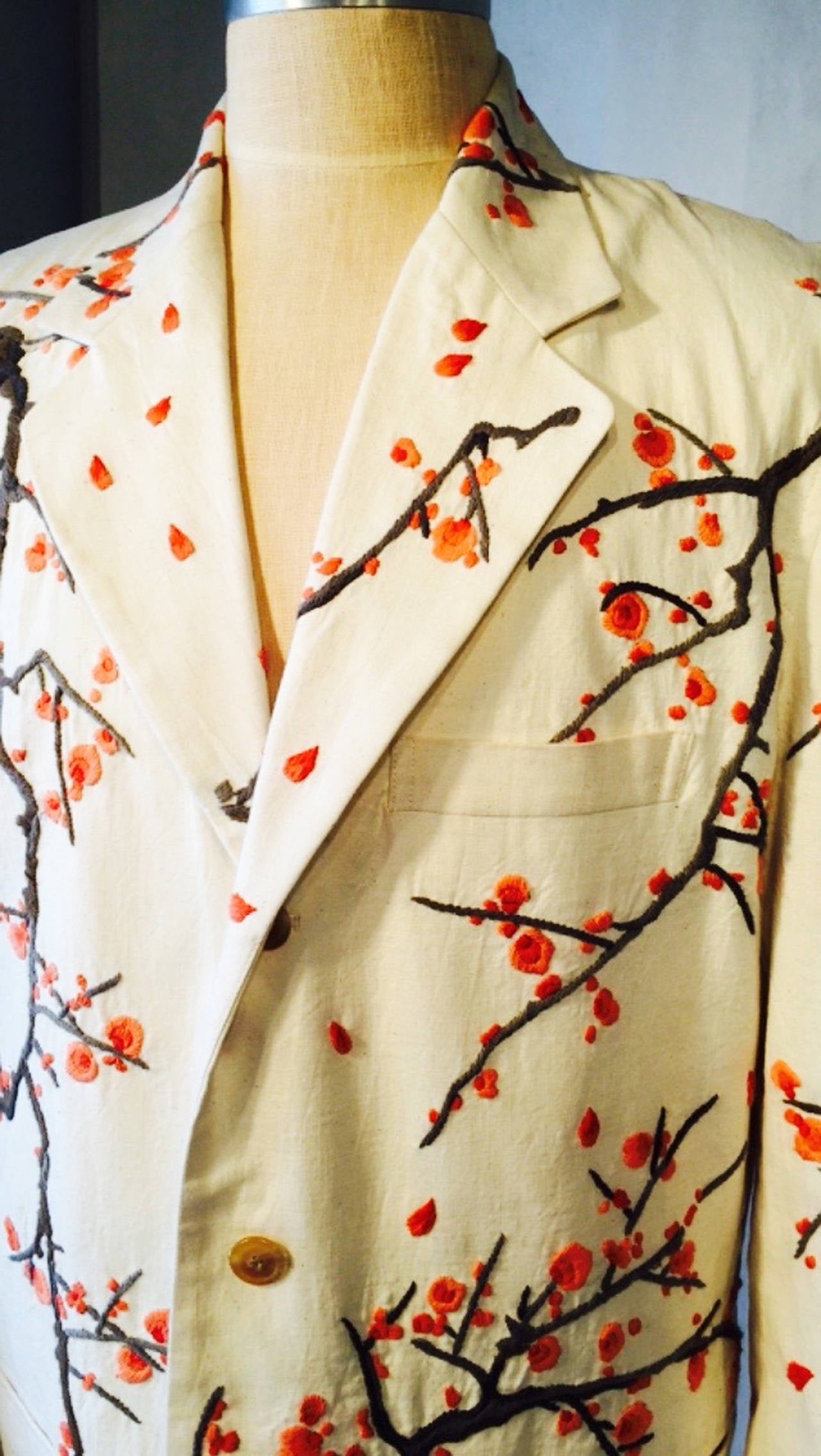 A fine vintage Issey Miyake gents embroidered jacket. Authentic ivory cotton item features beautifully embroidered front, back and sleeves in cherry blossom branches. Item fully lined with a three button front and no back vent. Item unworn with