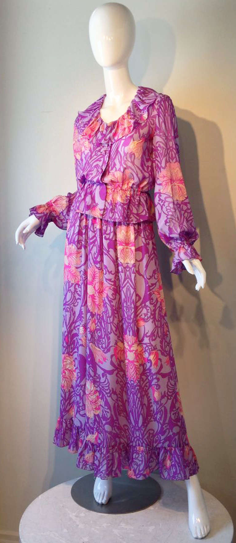 A exquisite Emilio Pucci 2pc. gown. Signed chiffon print fabric item include a nipped waist top with full cuffed sleeves, button front closures and ruffle trimmed neckline. Matching skirt features ruffle hemline. Items fully lined except sleeves.