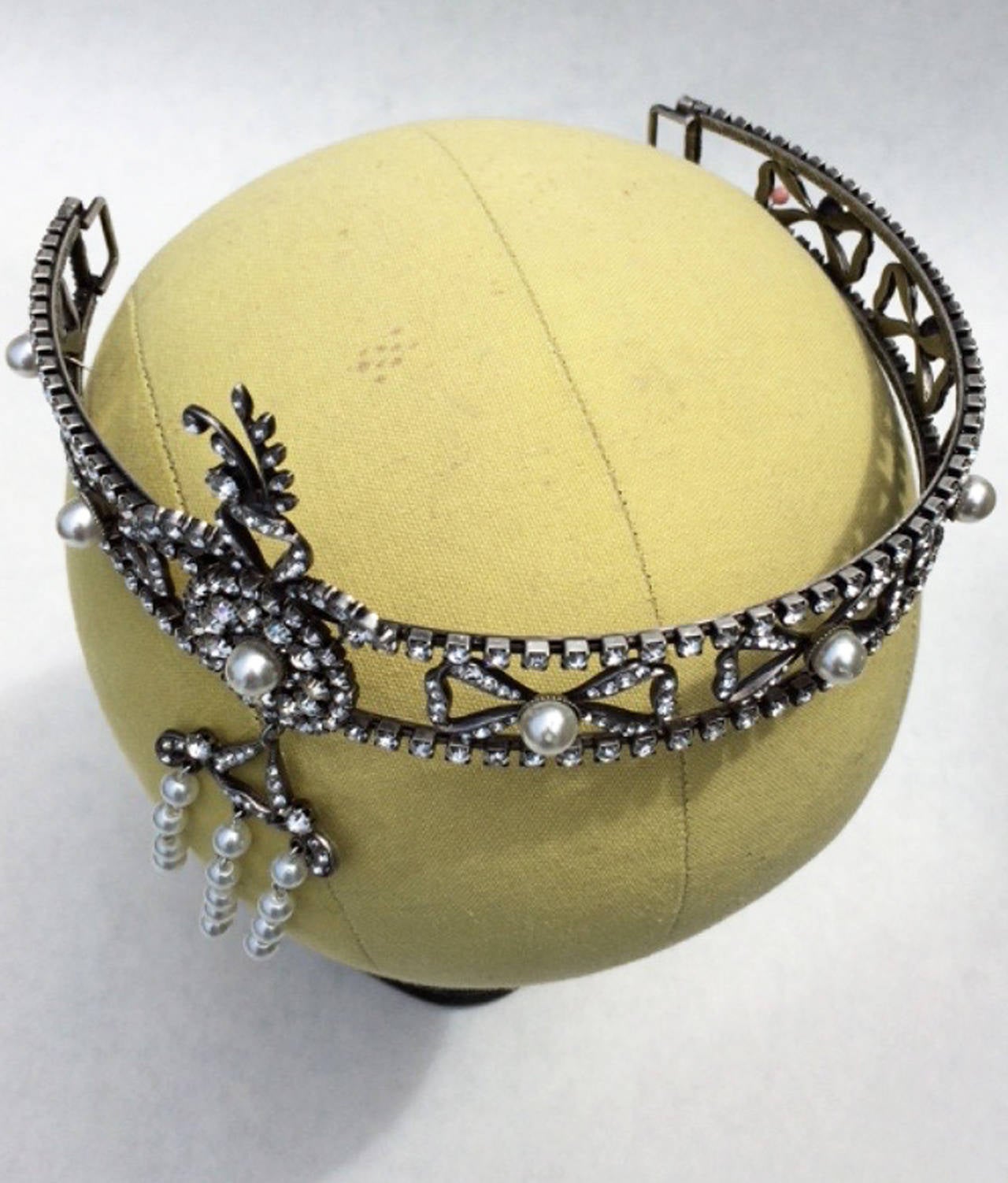 A fine and rare vintage diadem headband. Japanned brass engraved metal item features prong set crystals and faux pearl centers and pendant. Excellent.
