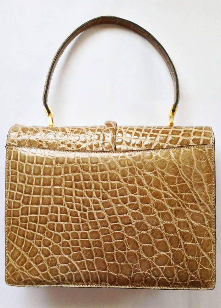A fine vintage Triomphe porosus crocodile handbag. Exquisite taupe highest grade skins item fully leather lined with gilt hardware and security lock closure. Matching handle features a 6