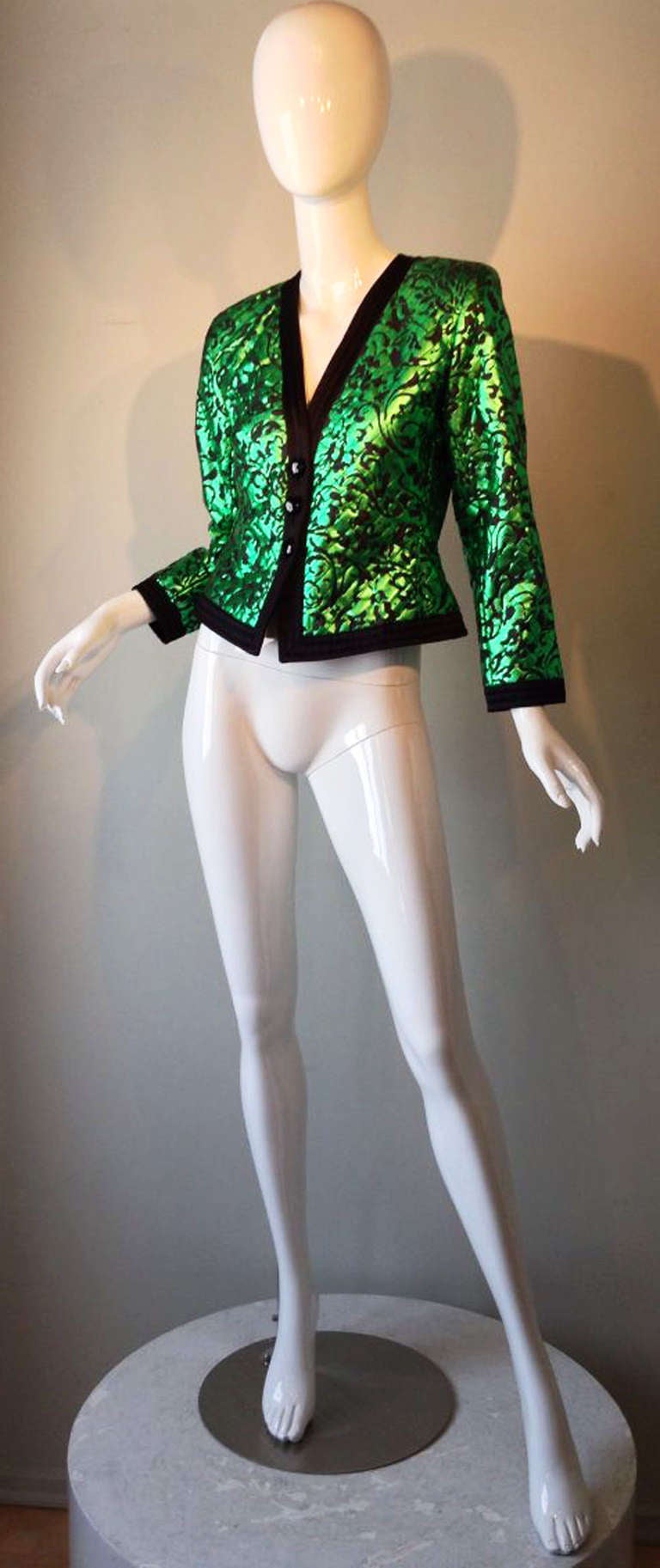 A fine vintage Yves Saint Laurent quilted evening smoking jacket. Exquisite green and black quilted silk printed fabric item trimmed in black silk. Item fully lined and jet glass button front closures. Pristine, perhaps unworn.