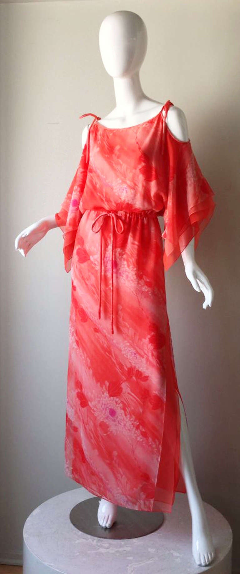 A fine vintage Travilla chiffon print gown. Triple level chiffon item features a floral print outer layer, handkerchief hems and sleeves, exposed shoulders and deep side vents. Built-in matching fabric shoulder and waist ties. Pristine, appears