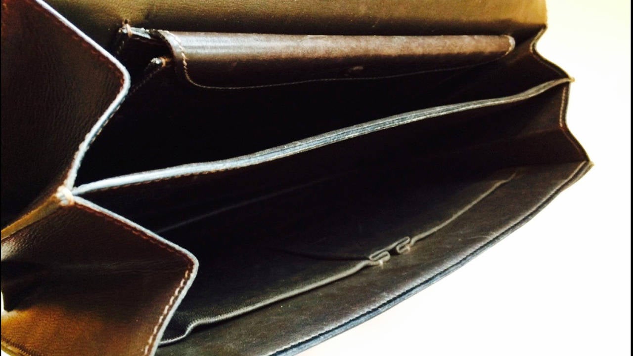 A fine classic vintage Hermes leather handbag. Authentic item features dark brown leather with a sculpted gilt push locking clasp closure and hardware. Item fully leather lined with a adjustable 8