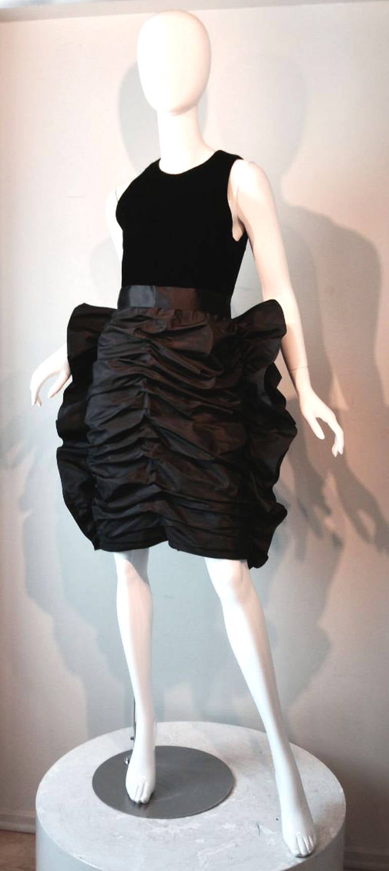 A fine and rare Givenchy haute couture cocktail dress. Hand constructed black velvet bodice and exquisitely sculpted skirt. Skirt ruched and pleated front to back. Item fully lined with metal zipper up back. A important and rare item appropriate for
