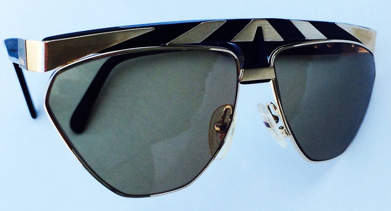 A fine and rare vintage pair Alpina sunglasses. Authentic item #1118403, size 63/13. Gilt gold items feature polished black plastic and original tinted lenses. Excellent with no issues.