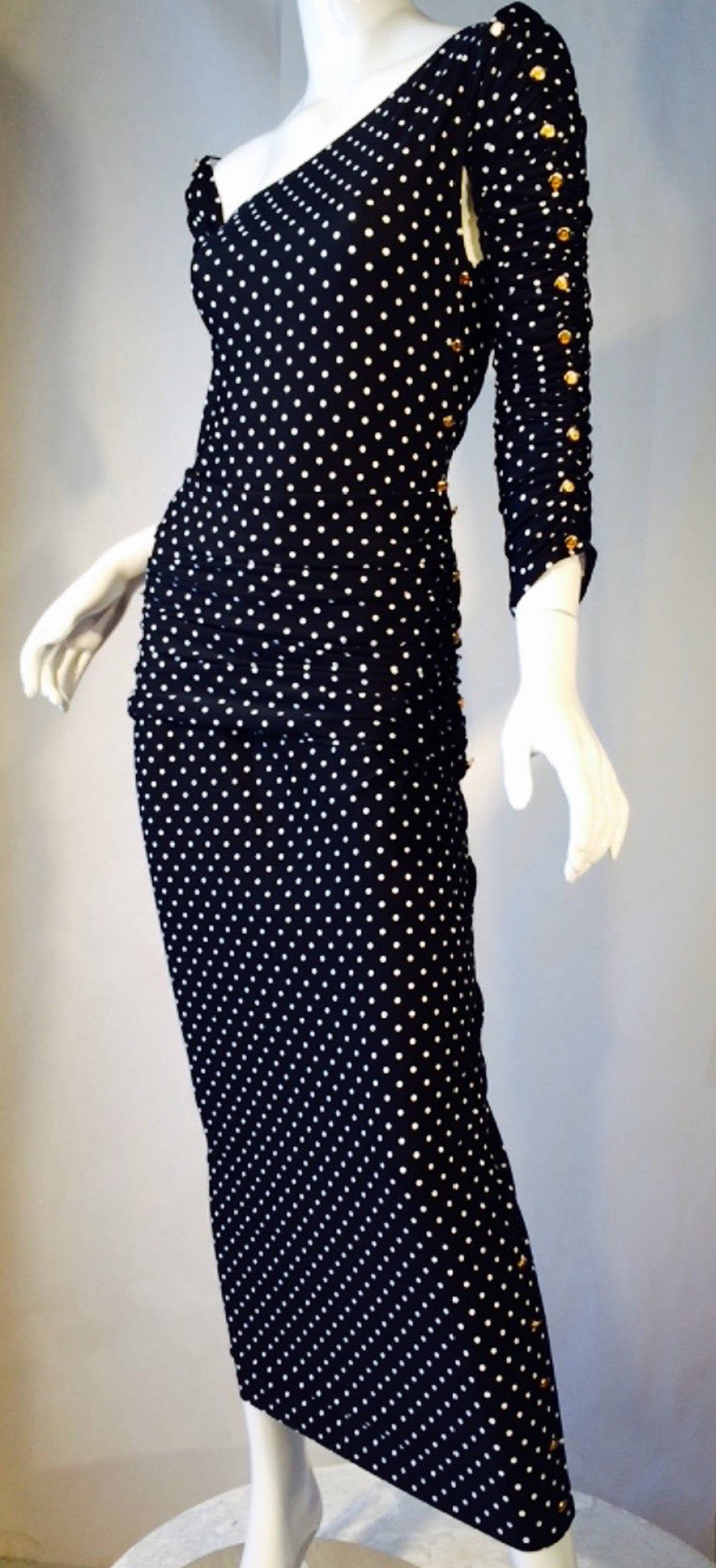A fine and rare vintage Chanel 4pc. swim/resort ensemble. A fine dotted body-conscious jersey knit model includes a bodysuit, sleeves and both mini and full skirts. Signed gilt metal logo button trim up skirts, bodysuit and sleeves. Pristine appears