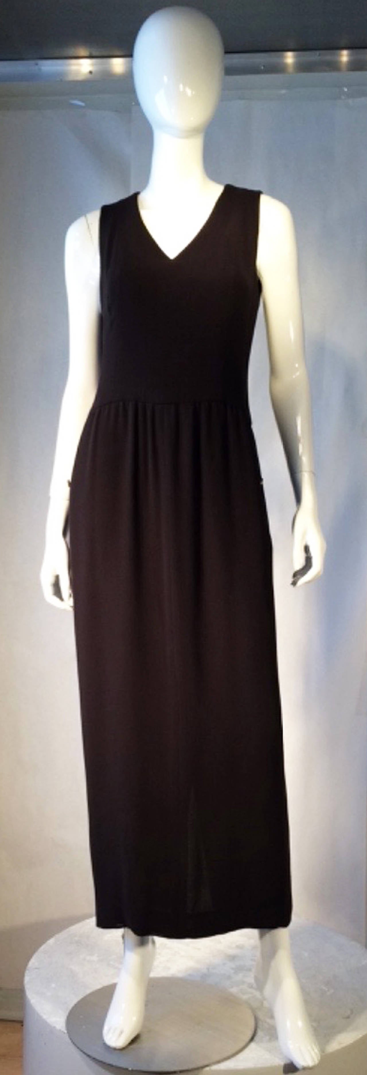 A fine vintage Chanel maxi sheath dress. Authentic loosely woven cocoa brown wool item features a defined waistline, fully silk lined with hidden side pockets. Additionally, item zips up back with Chanel button secure side pockets. Pristine,