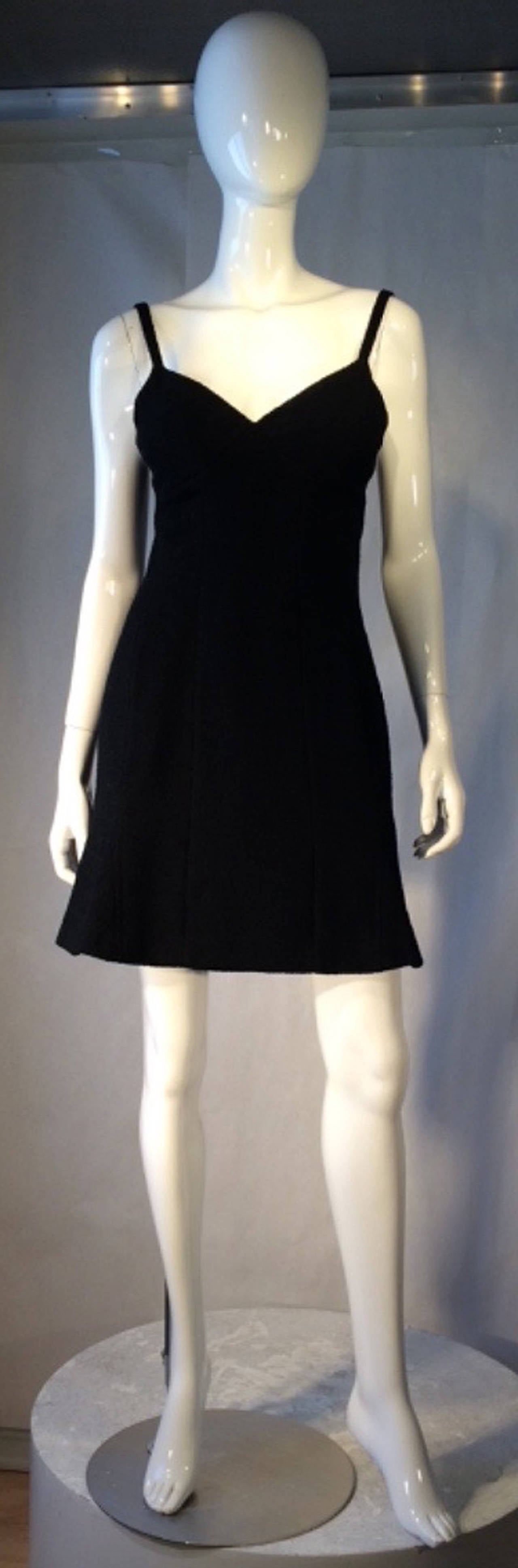 A fine vintage Chanel little black cocktail dress. Authentic wool frisse fabric item features precision seams, flounce hemline and shoulder straps. Item fully silk lined and zips up back. Pristine.