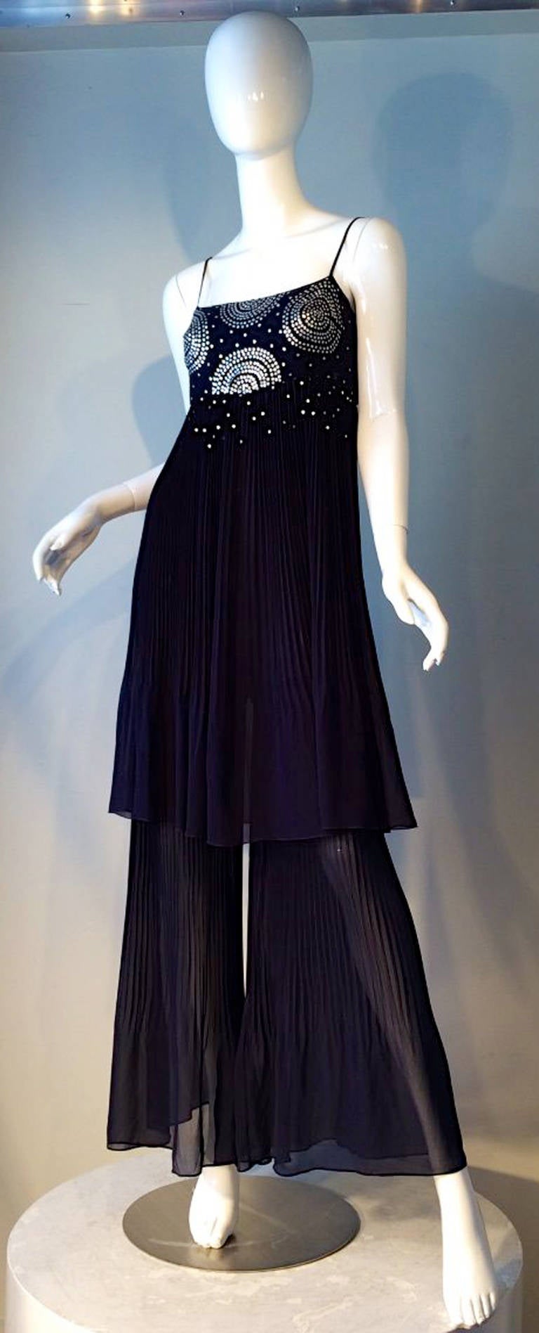A fine Chanel evening jumpsuit. Sunburst pleated navy silk chiffon item features a sequin decorated bodice and wide pleated trousers. Item fully silk lined and zips up side. Pristine appears unworn.