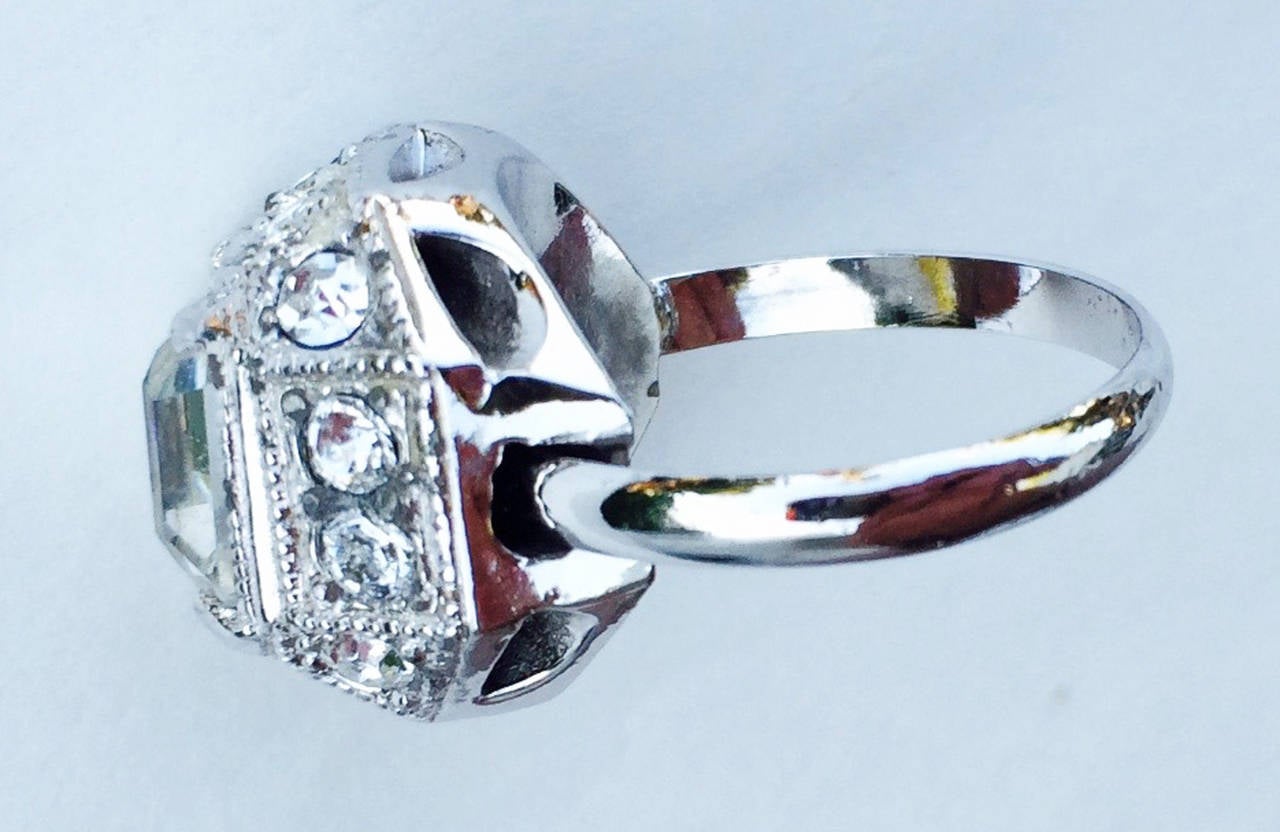 A fine & rare vintage Eisenberg faux diamond cocktail/engagement ring. Rhodium plated metal item features a large sparkling square cut crystal center with crystal surrounds. Shank adjust to fit. Excellent.