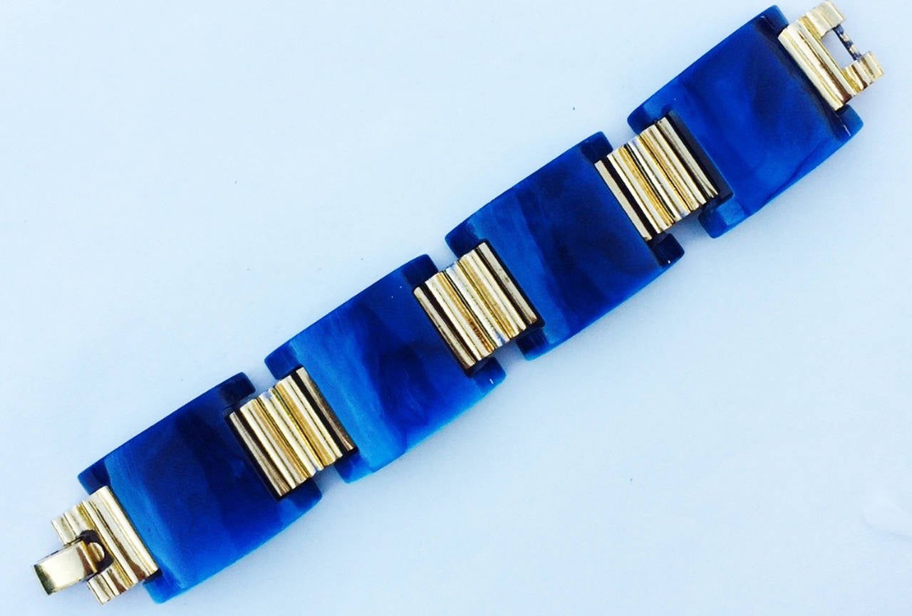 A fine vintage Trifari Lucite link bracelet. Authentic signed gilt metal item features marbleized blue Lucite curved links with sculpted gilt spacers. Original locking clasp intact. Excellent.