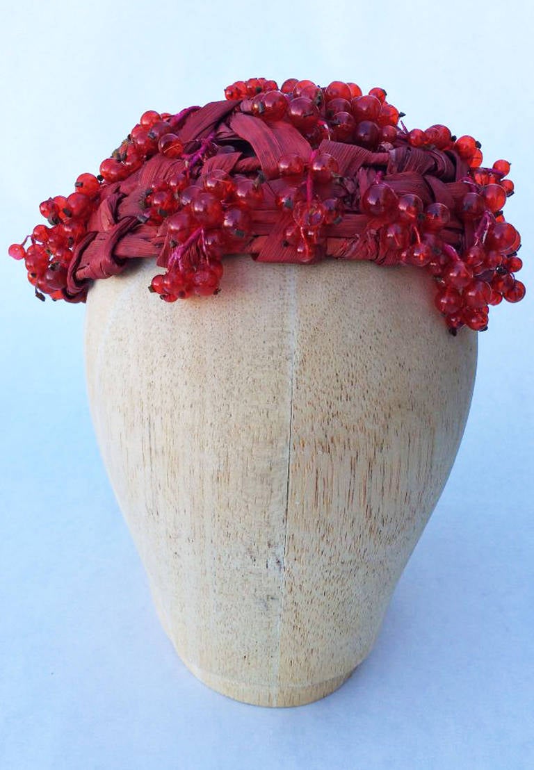 A fine and extremely rare vintage Christian Dior haute couture hat. Braided and dyed red raffia item covered in delicate miniature red glass 