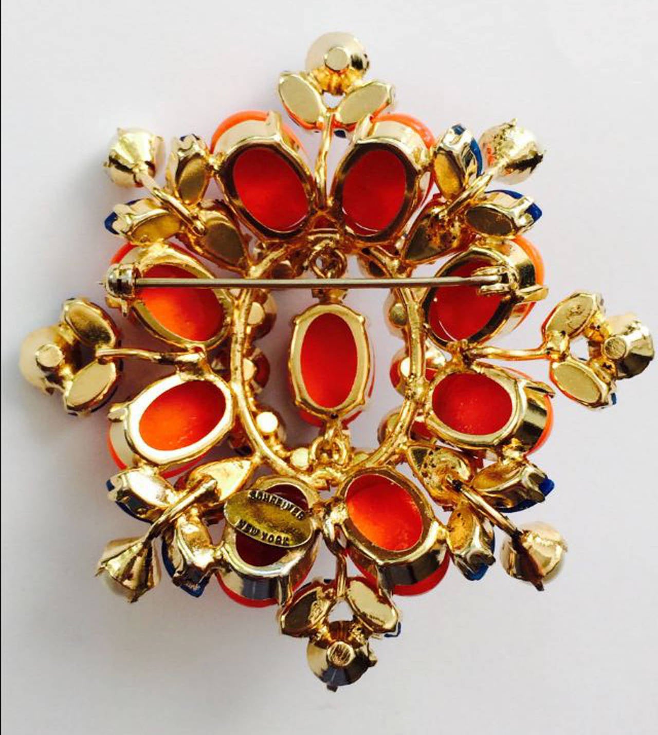 A fine vintage Schreiner New York brooch. Signed gilt metal item features faux coral, Lapis, pearls and crystals. Pristine appears unused.