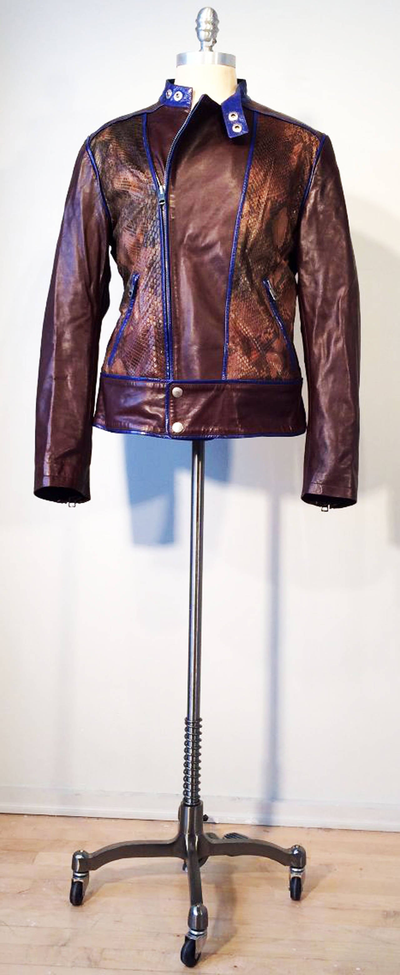 A rare Tom Ford for Gucci python cafe racer/biker jacket. Supple brown leather item features matching color python panels and contrasting electric blue leather trim. Item fully lined with both zipper and snap closures. Pristine appears unworn.
