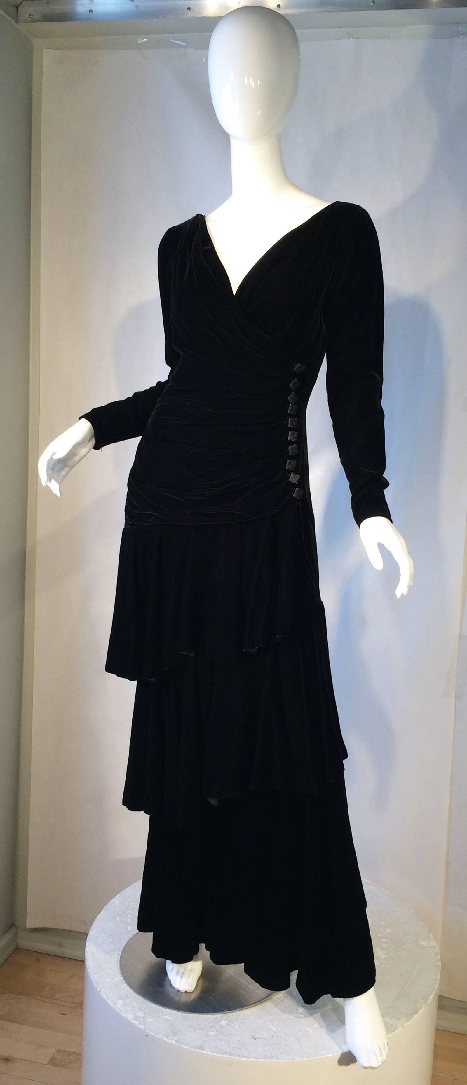 A fine vintage Lanvin evening gown. Exquisite black velvet item features a ruched bodice and spiral tiered floor length skirt. Item fully silk lined with a built in boned bodice. Item interior zips with exterior button closures. Excellent item with