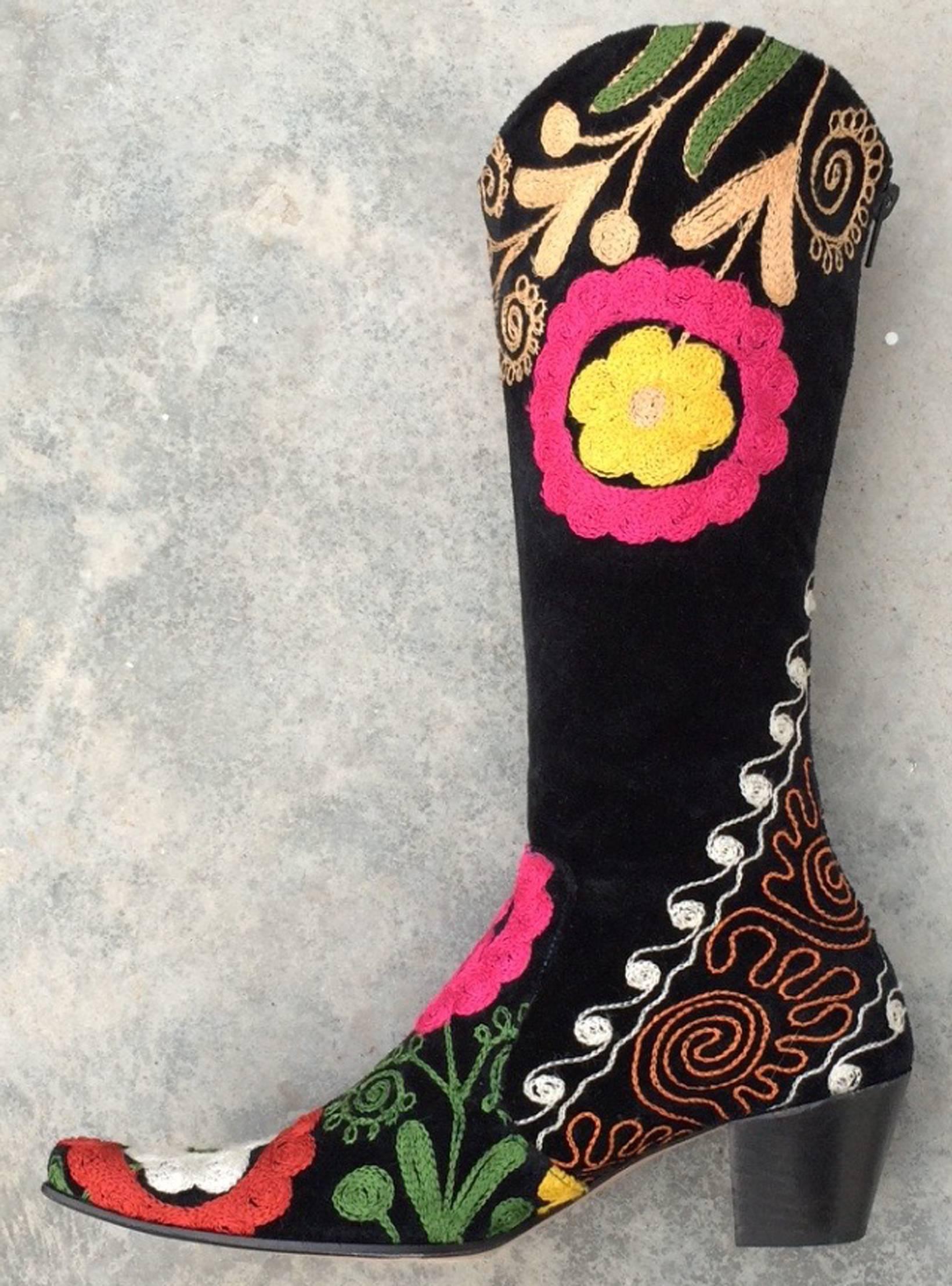 A fine vintage pair ethnic/gypsy style embroidered boots. Previously unworn items feature multi-color embroidered black velveteen uppers, calf lined interiors, leather soles and zipper closures. Items marked size 38 with 2