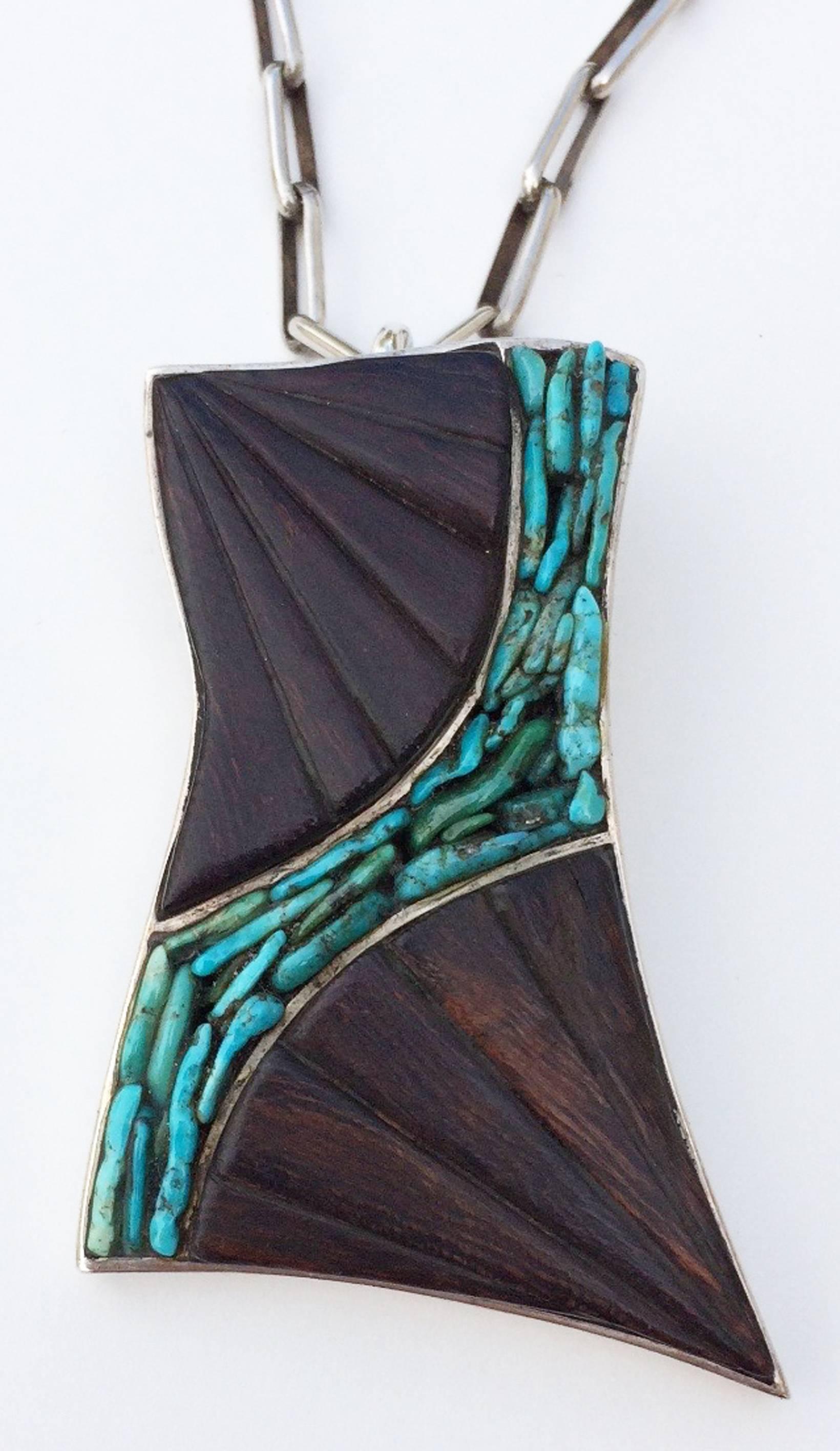 A fine and rare Paul Durkee studio modernist pendant necklace. Signed sterling silver pendant features channel set carved and polished ironwood and turquoise nuggets in a free form organic setting. Original hand constructed 24