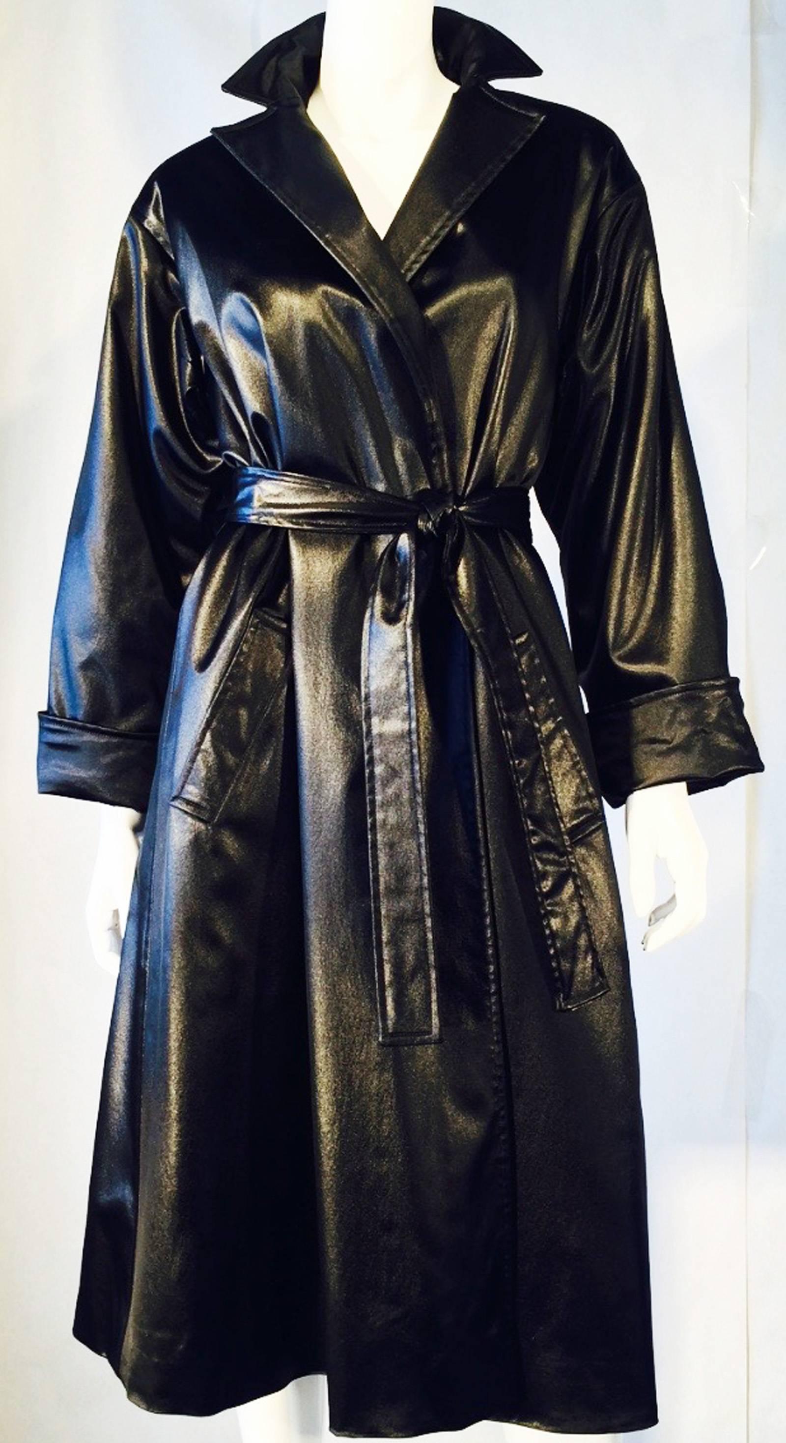 A fine and rare vintage Halston belted satin coat. Black silk item features a wrap front and attached matching sash belt. Pristine appears unworn.
