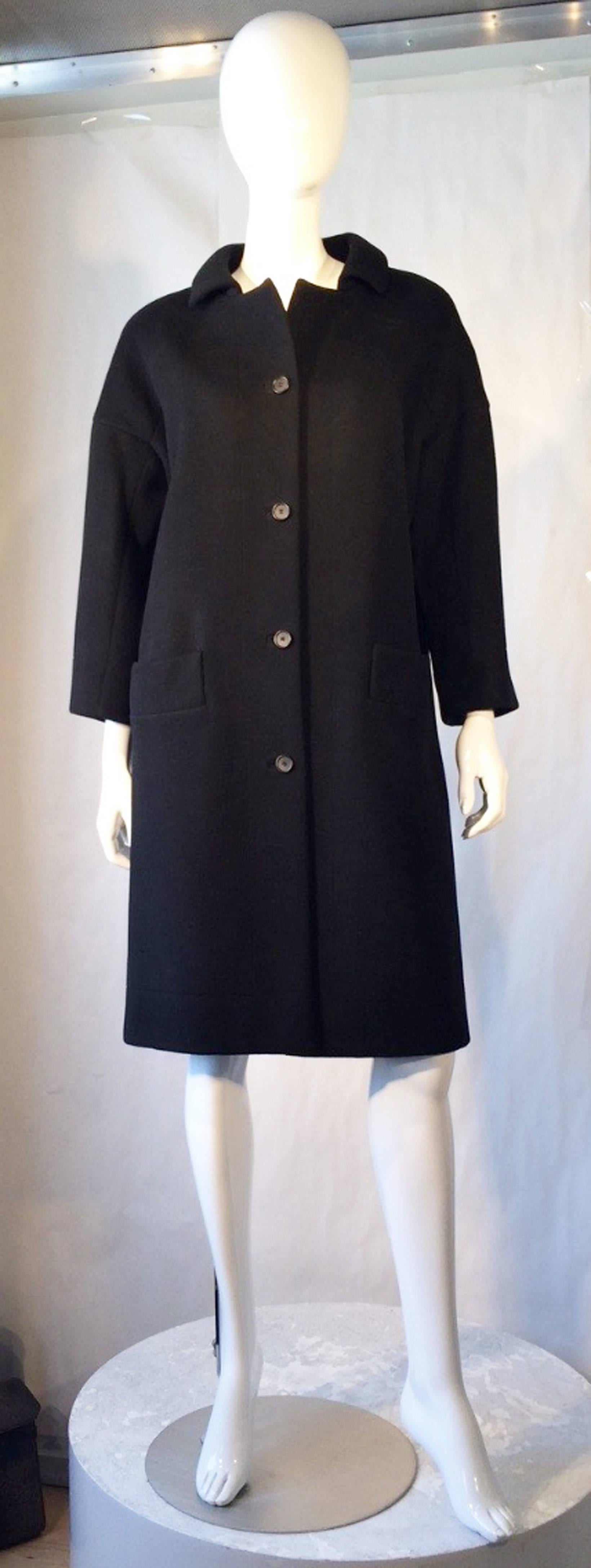 A fine and rare vintage Balenciaga haute couture coat. Authentic client numbered jet black felted wool item features precision seams, button front closures, front side pockets and fully silk lined. Excellent.