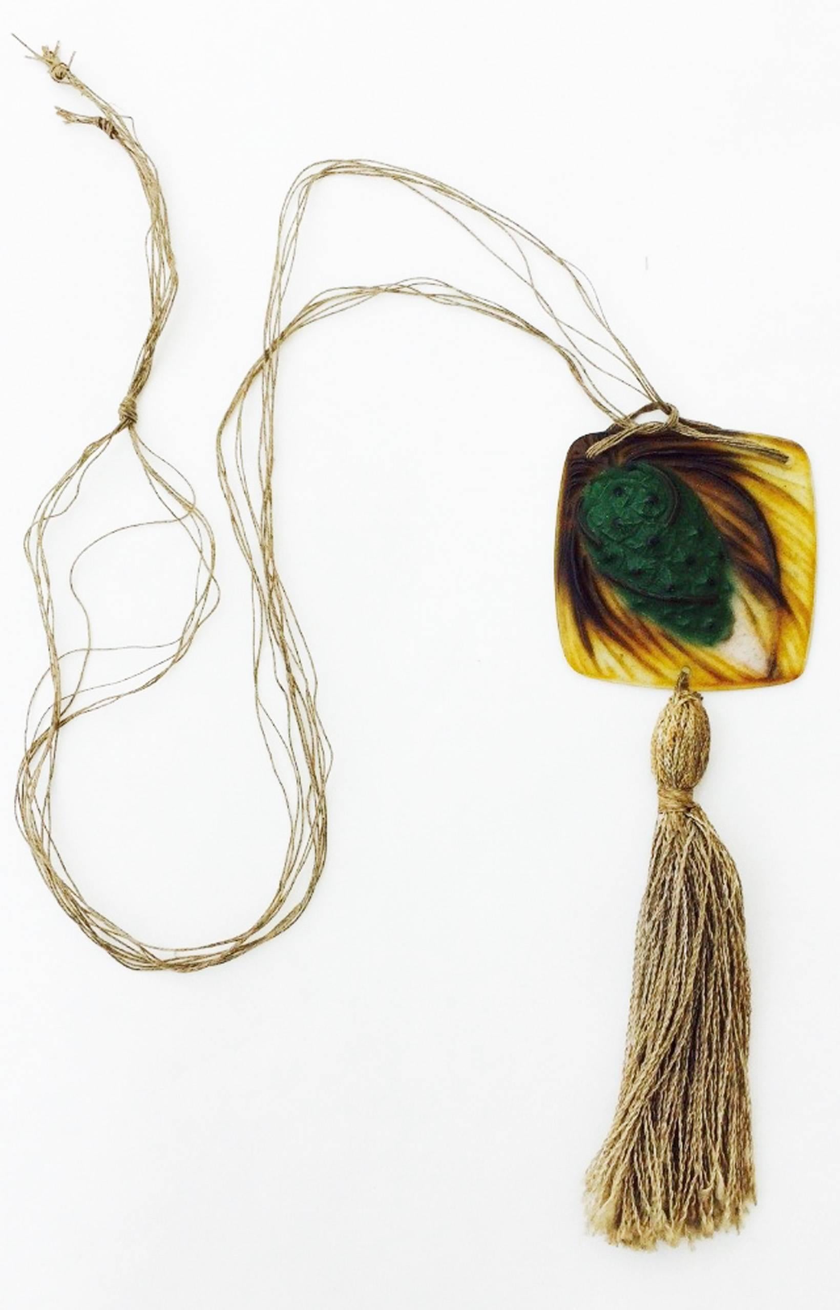 A fine and rare Gabriel Argy-Rosseau pate de verre pendant necklace. Signed and early art deco period item depicts a pinecone and needles and retains original silk cord and tassel. Outstanding design and execution. Glass pendant measures 2