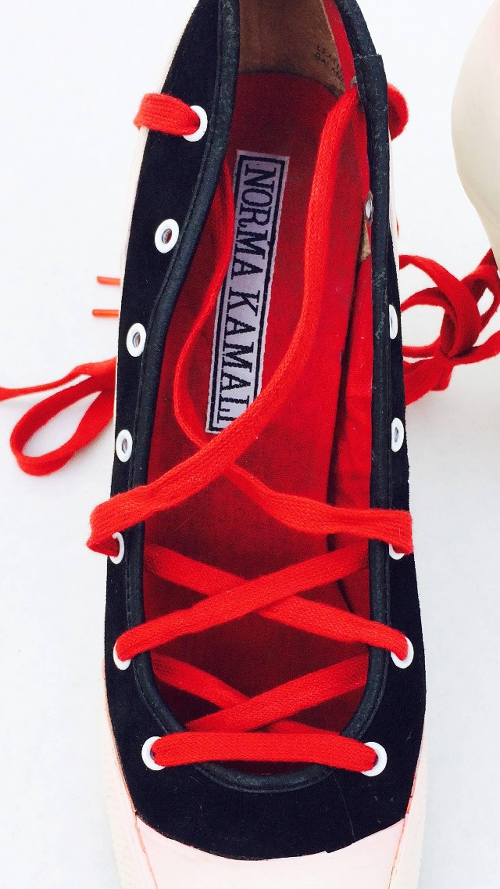 A fine and iconic pair vintage Norma Kamali high heel sneakers. Black canvas items feature original vibrant red laces and off-white rubber soles and 4