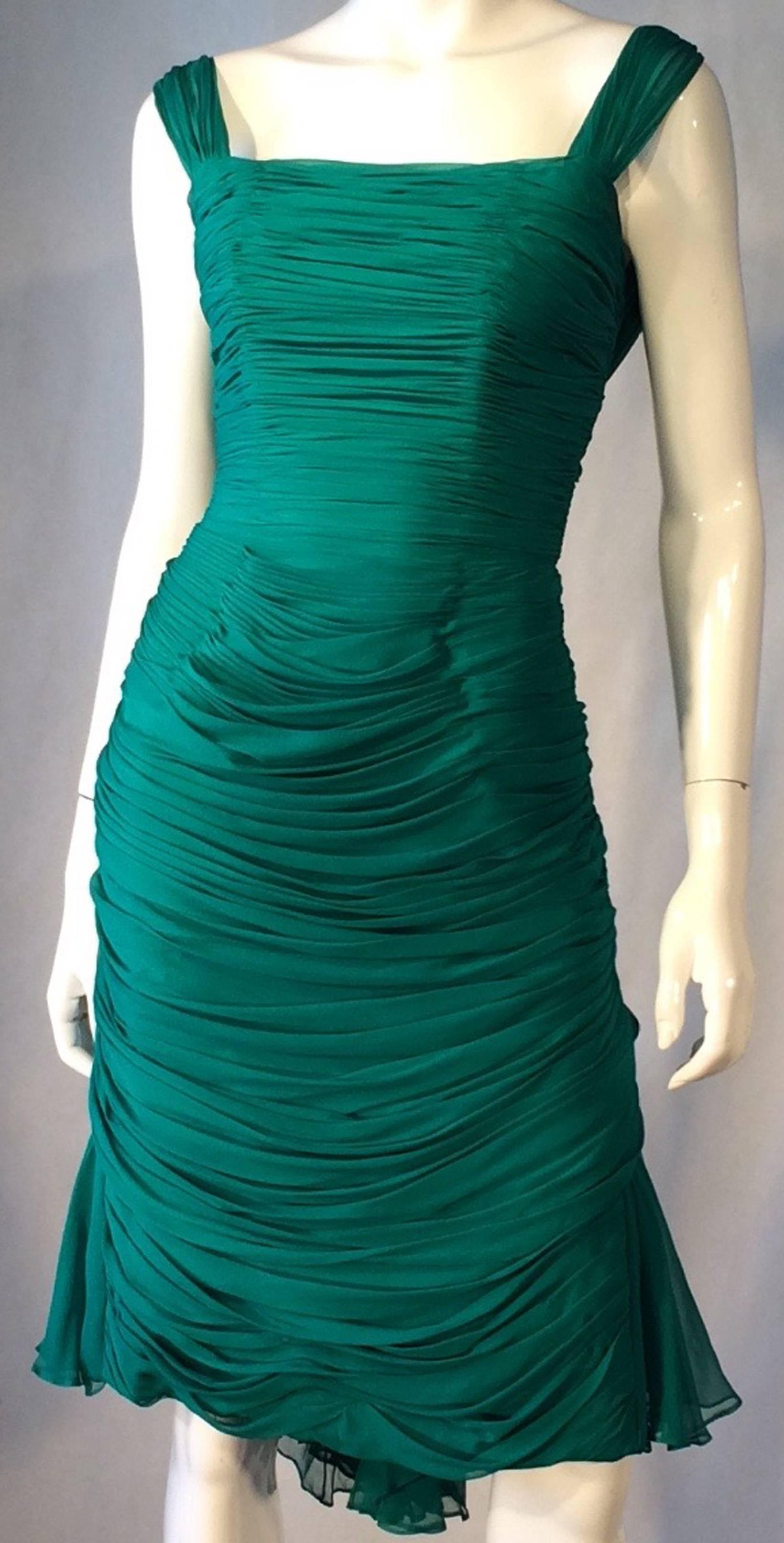 A fine and rare vintage Jean Desses silk chiffon cocktail dress. Stunning emerald green silk chiffon item features paneled and ruched details with draped back and flowing train. Item fully lined with a boned bodice and zips up back. 
