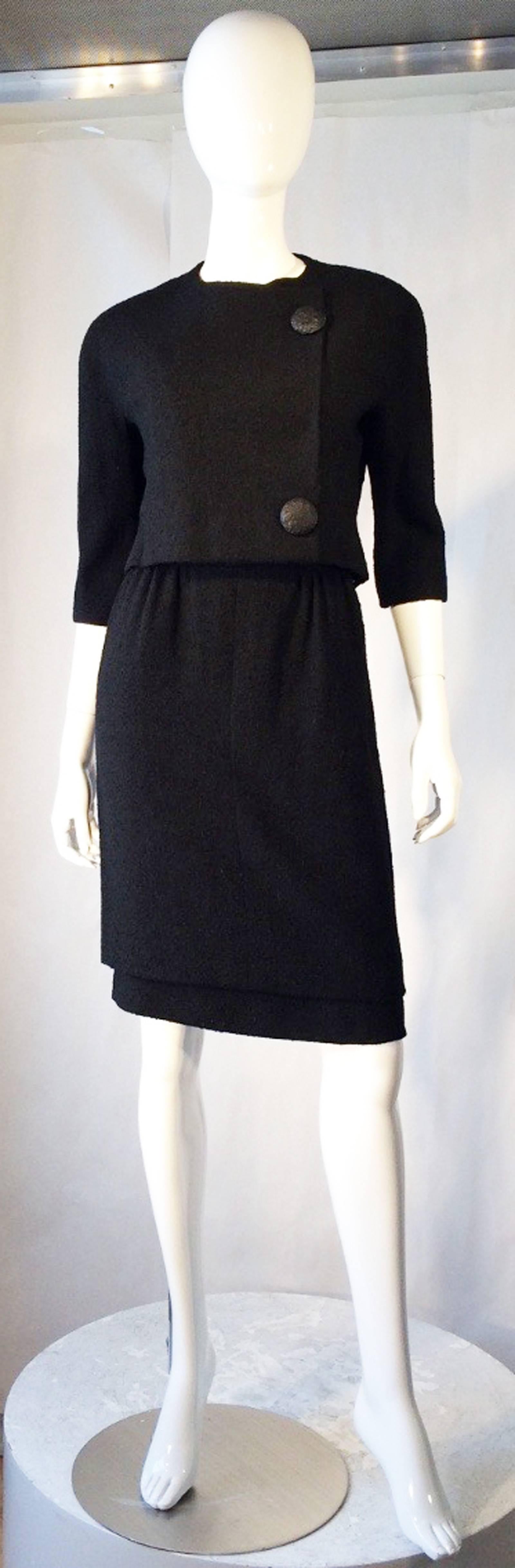A fine and rare vintage Balenciaga haute couture dress suit. Authentic numbered and documented item retains original hand written Balenciaga order receipt dated 1957. Jet black 2pc. wool frise fabric items feature precision seams with original