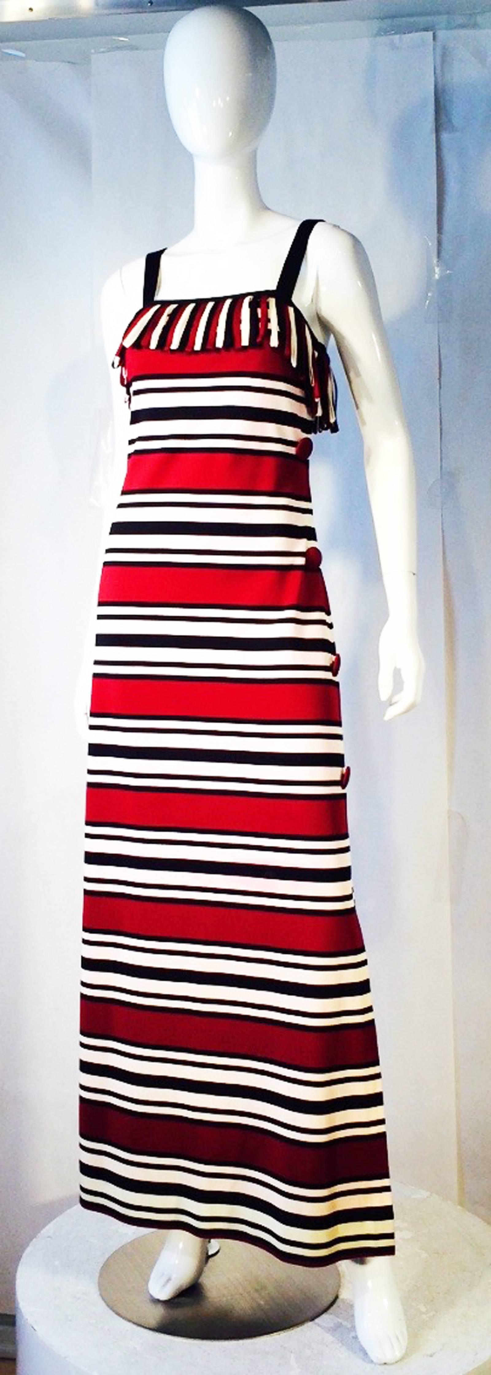 A fine vintage Pierre Balmain knit maxi gown. Authentic synthetic knit item banded in graphic horizontal stripes. Item features a looped matching fabric car wash trimmed bodice with shoulder straps. Item fully silky lined and closes up side.