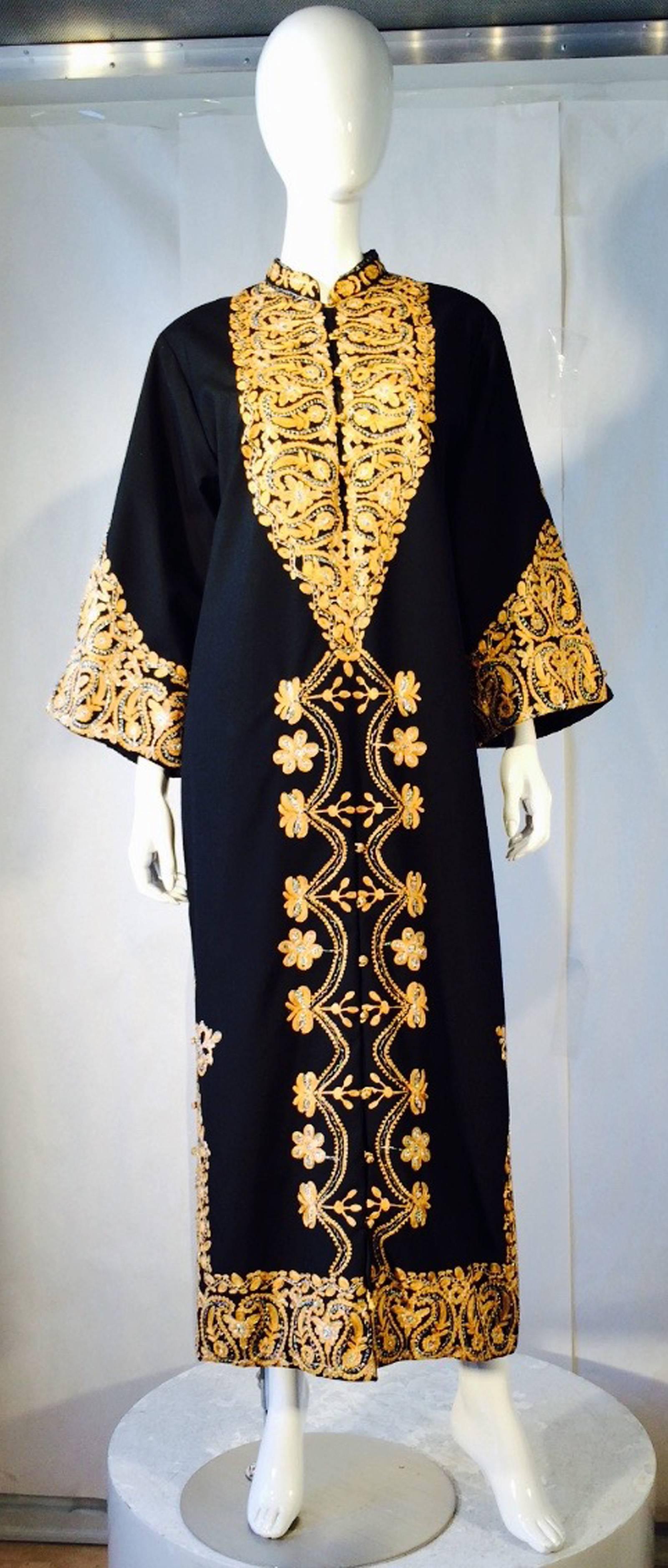 A fine vintage Moroccan caftan gifted by King Hassan II of Morocco. Authentic item presented at the Moroccan Embassy in Paris France, 1970. Black natural fiber item features elaborate metallic embroidery front and back. Item buttons down front