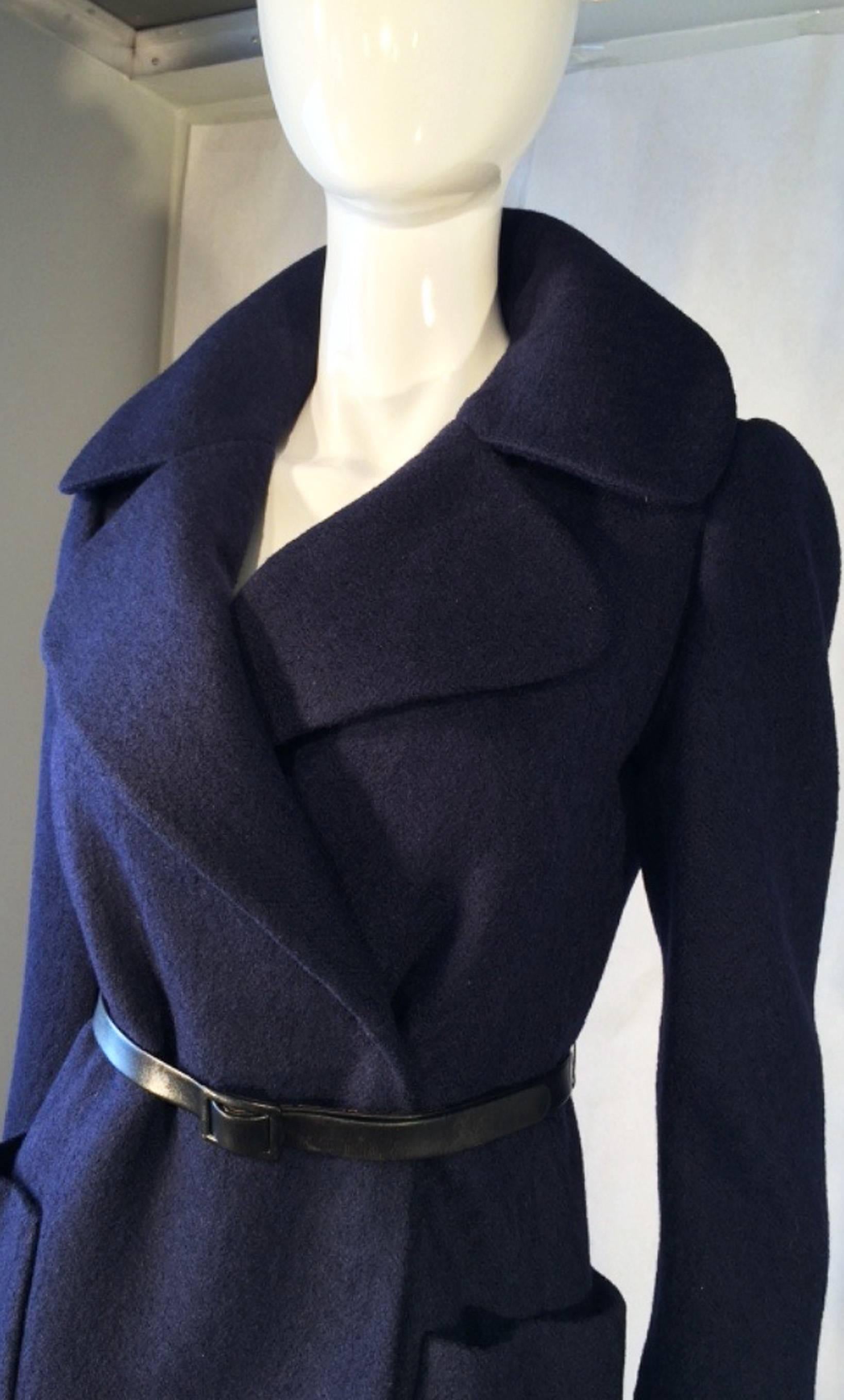 A fine and rare vintage  Norman Norell runway/sample jacket. Navy wool fabric item features a wrap front and fully silk lined. Item retains original signed leather cinch belt with partial missing belt lining (neither detracts nor diminishes). Rare