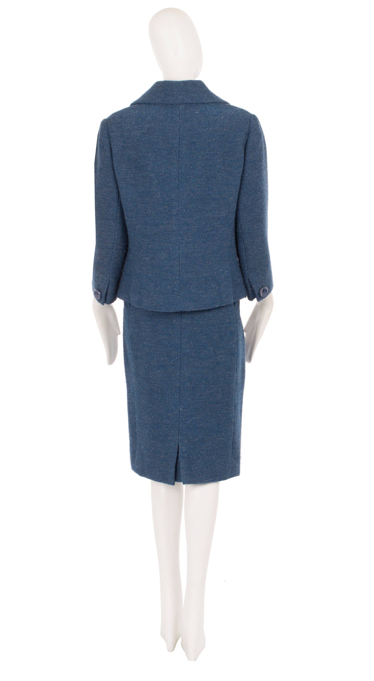 This classic Dior skirt suit in a wonderful shade of blue wool is the perfect option for the office. Expertly cut, the jacket features a wide double lapel collar and pocket detail on the hip. A single button fastens on the waist, with an additional