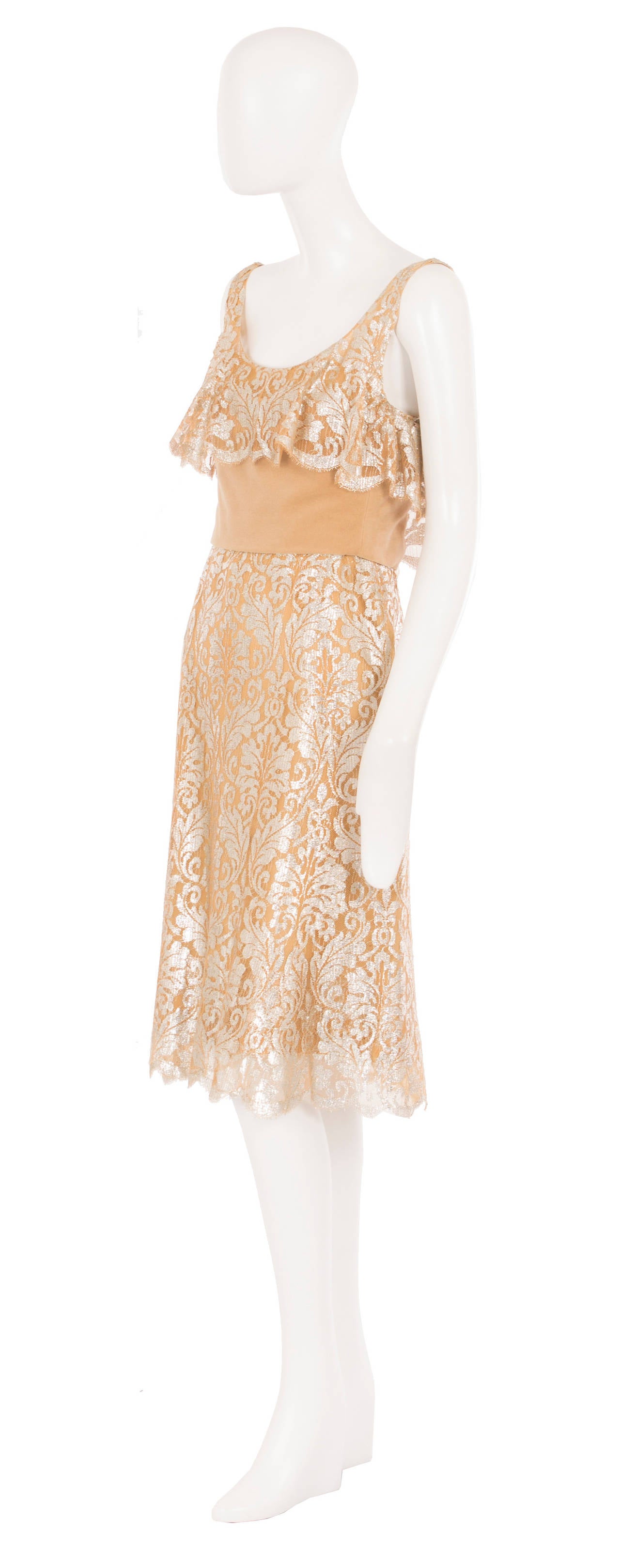 This exquisite piece of haute couture is the epitome of chic and a superb example of Marc Bohan’s early years at the house of Dior. Constructed in caramel-coloured lace shot through with silver lurex, the dress features a ruffle details over the