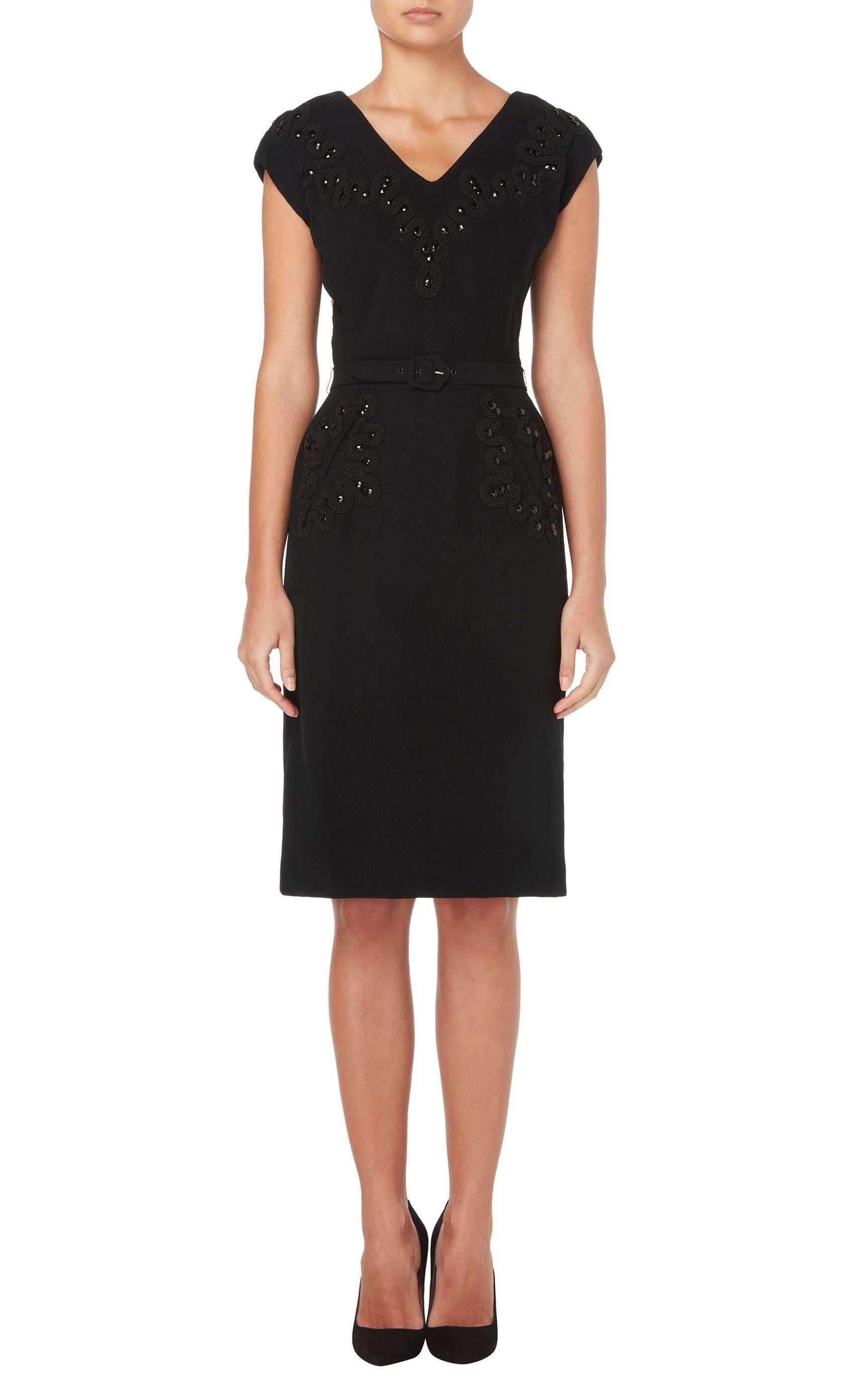 This stunning Balenciaga little black dress will make a fantastic addition to a modern wardrobe. Constructed in black wool crepe, the dress features a deep v-neckline and capped sleeves. The fabric-matched belt draws attention to the waist, while