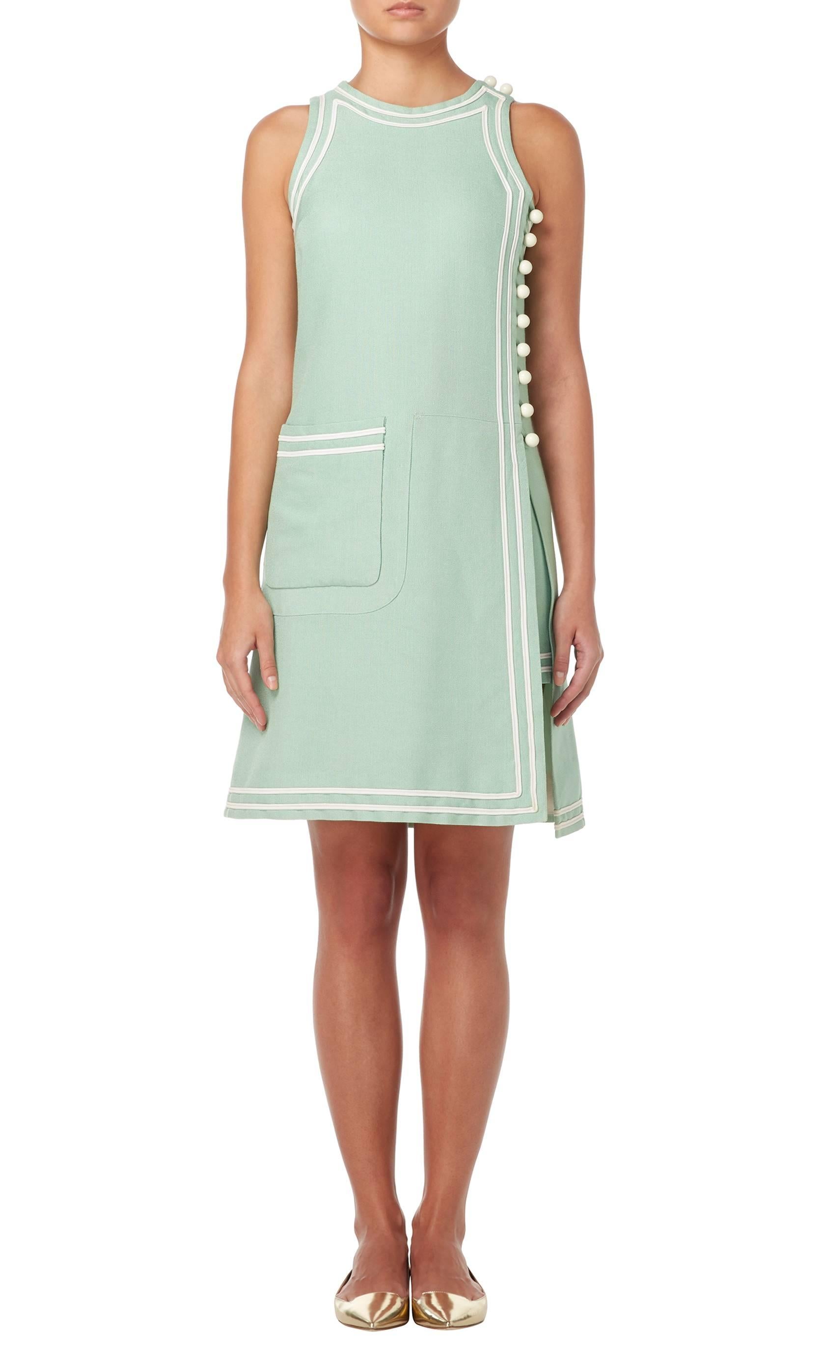 Constructed in mint green cotton with ivory cotton pique trim
Comprising of a tunic and shorts
Featuring ivory buttons and pocket on the tunic
Zip fastening to rear of the shorts
Excellent condition with original label, lining and
