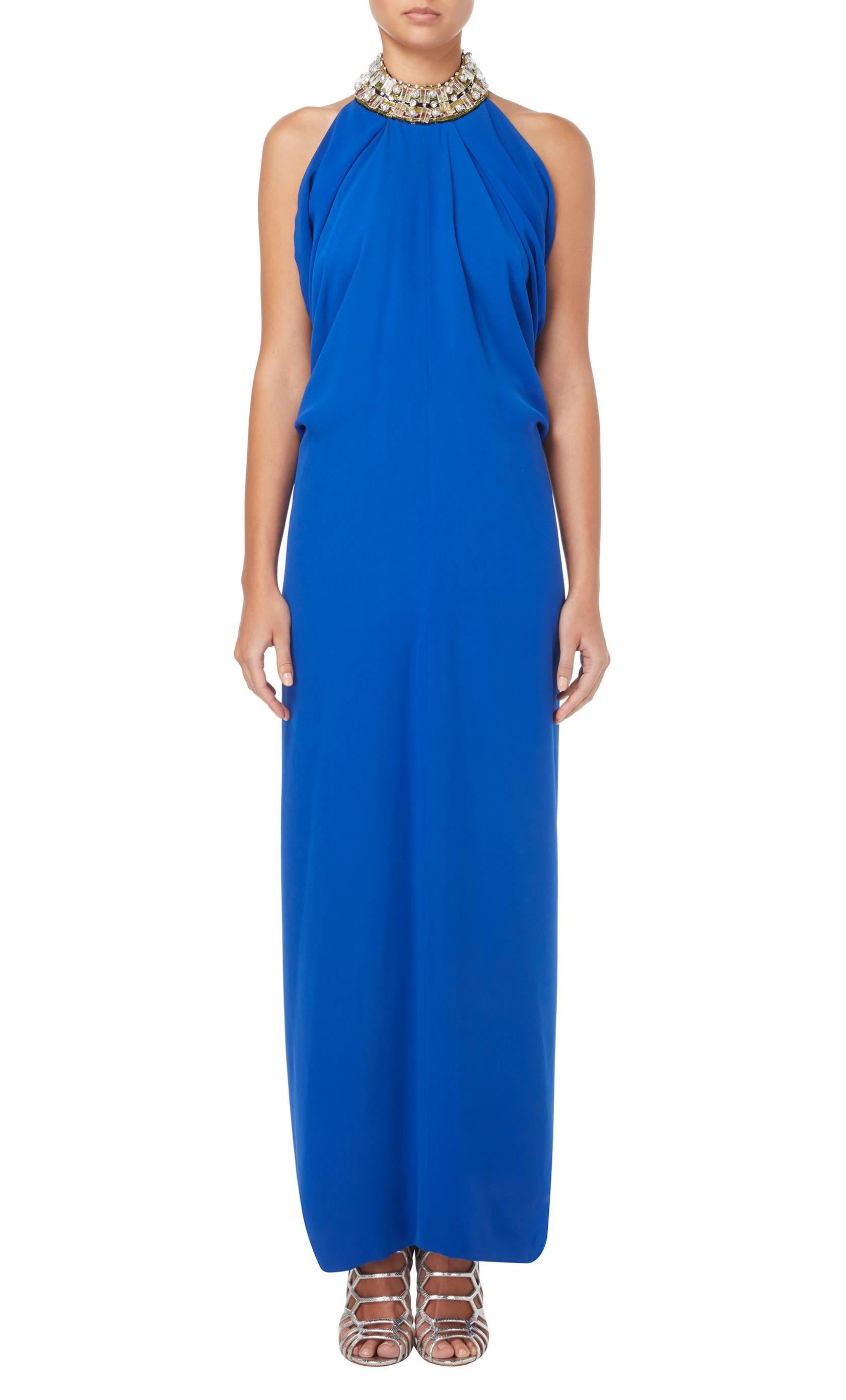This haute couture gown by Pierre Cardin is simply stunning and will make a for a bold red carpet look. The bright blue silk crepe is expertly draped over the bust and waist and is gathered with an elasticated waistline to the rear. The halter neck