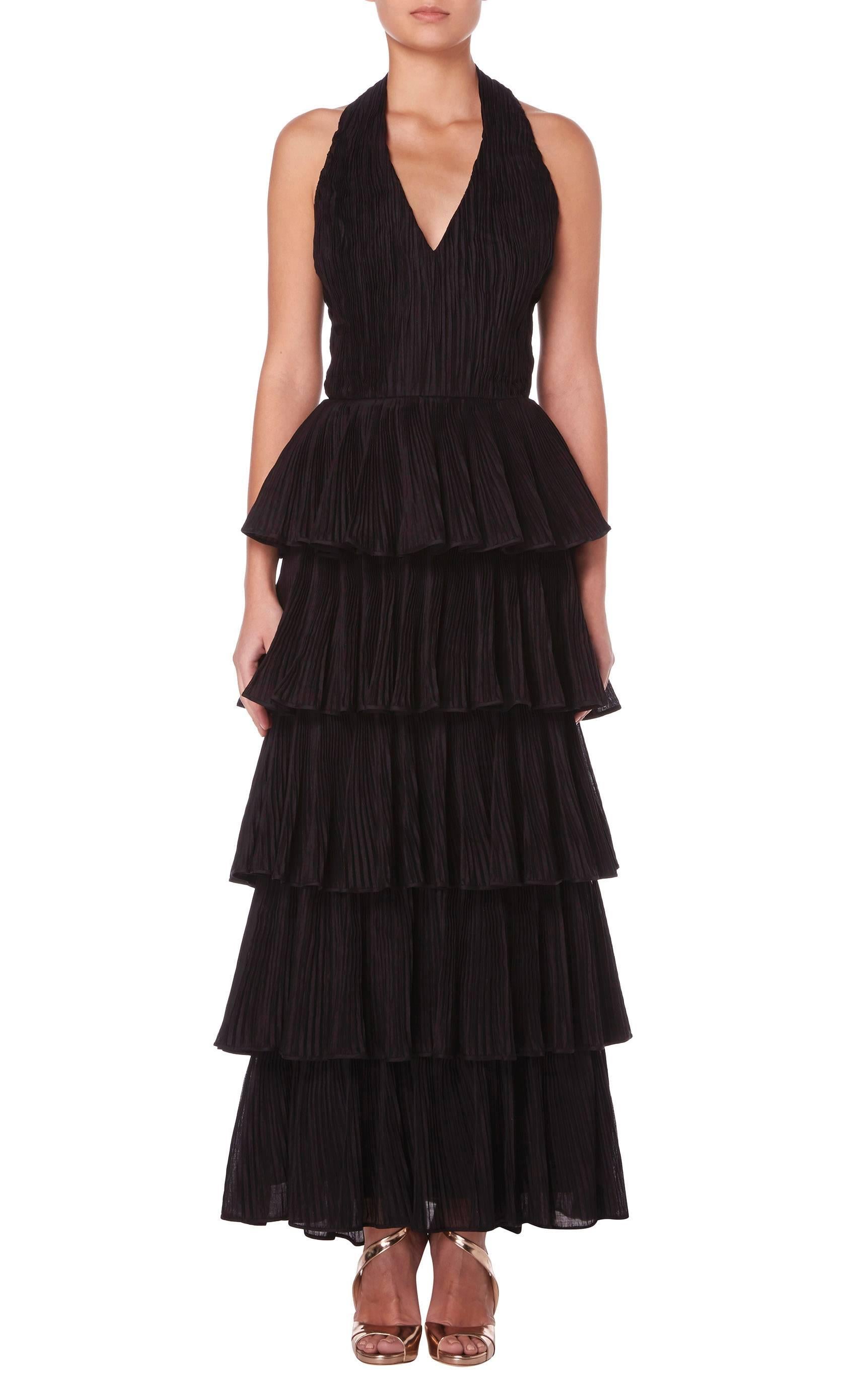 
A fantastic example of Sybil Connolly's signature style, this stunning halterneck gown would make the perfect choice for a red carpet event. Constructed in micro-pleated black linen, the gown features a flattering v-neckline and has an exposed