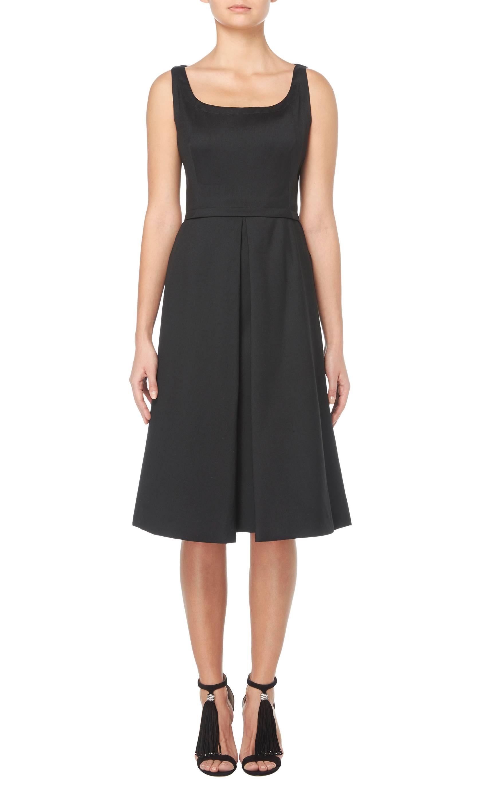This classic little black dress by Nina Ricci is a great wardrobe staple. With a flattering scooped neckline, the dress is fitted on the bust and a waistband draws the eye to the small of the waist. The skirt flares out into an A-line silhouette and
