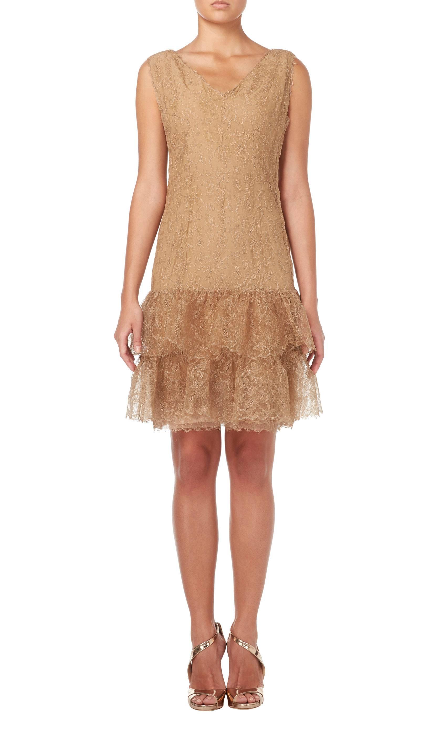 A stunning piece of haute couture, this Balenciaga cocktail dress is constructed in caramel lace and lined in silk. The perfect choice for parties and cocktail events, the sleeveless dress features a flattering v-neckline and drop waist silhouette.