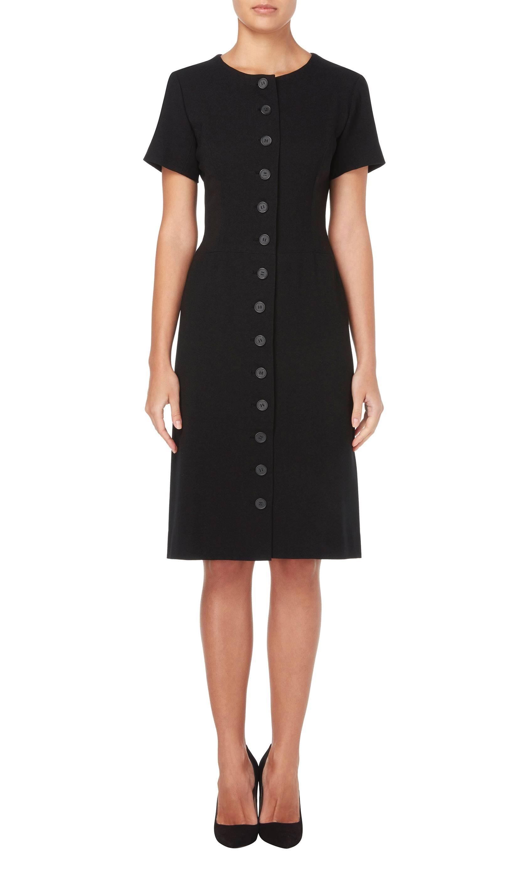 A beautiful piece of Balenciaga haute couture, this dress will be the perfect addition to a modern wardrobe. Whether worn for the office or out to a dinner this expertly cut piece, constructed in black wool, is an utterly chic choice. Featuring a