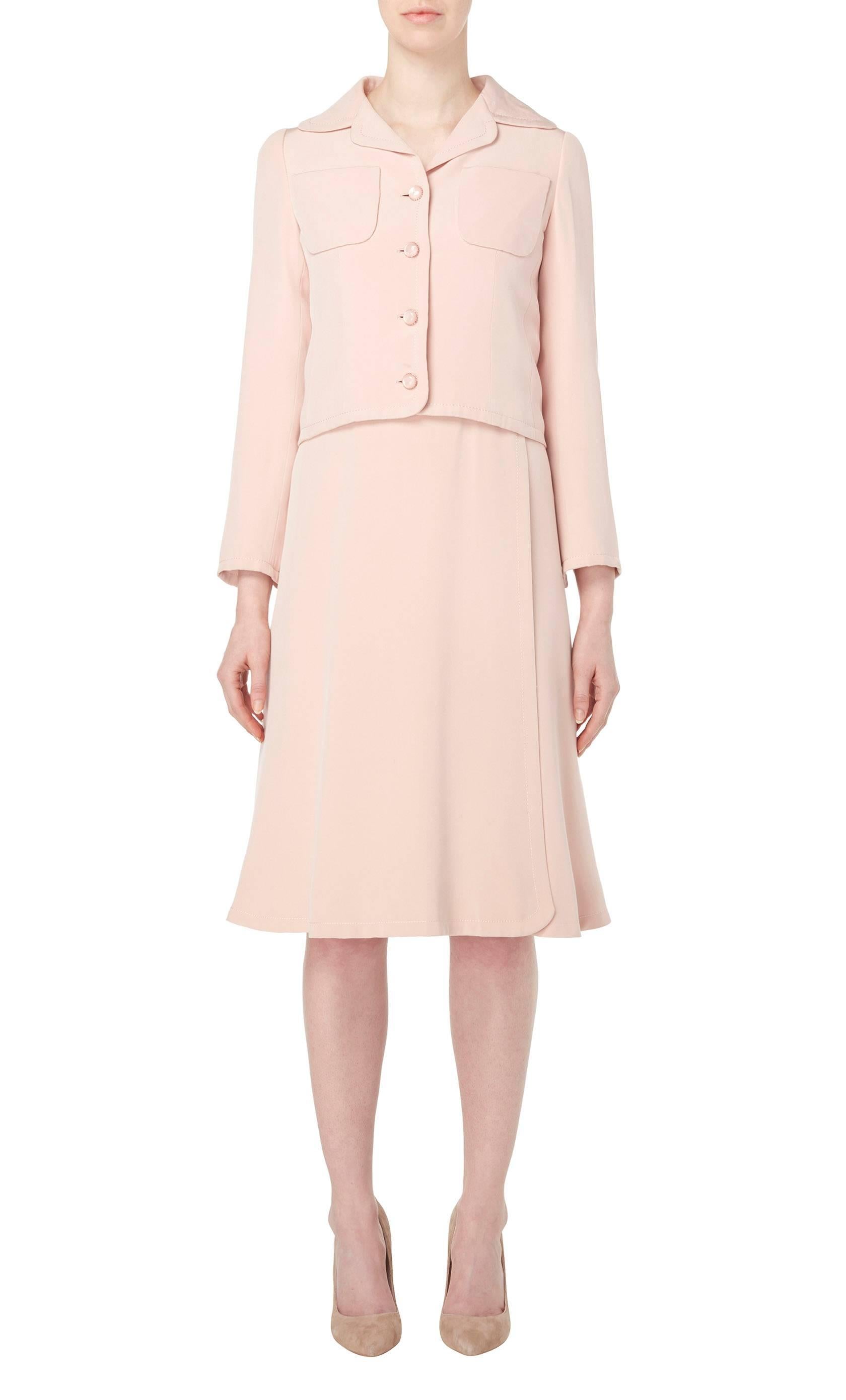 
A gorgeous piece of haute couture, this Guy Laroche dress suit constructed in pale pink silk, is perfect for daytime events. The sleeveless dress has an extremely flattering cut, skimming the body and flaring into a softly pleated skirt. The belt