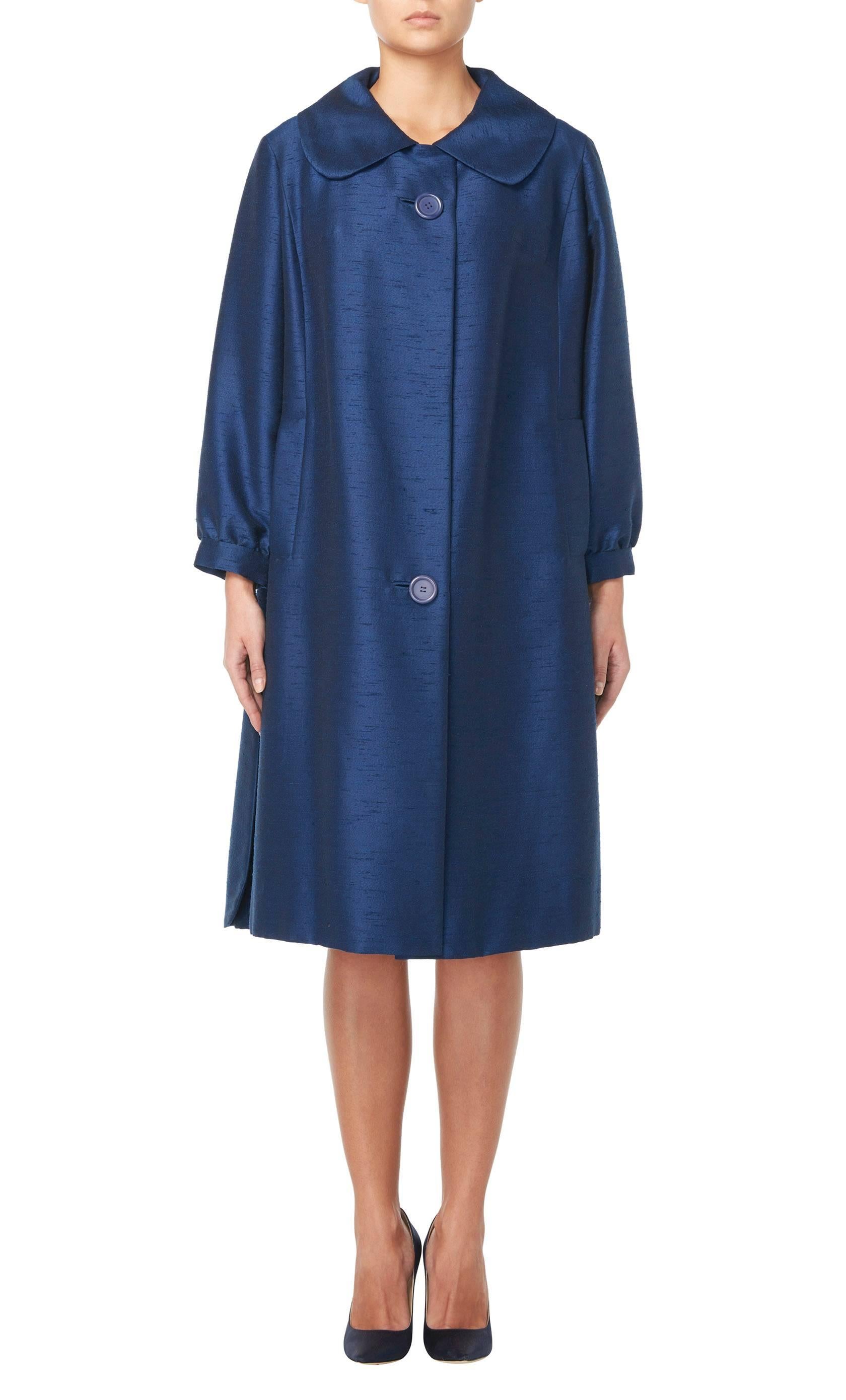 This Lanvin coat is constructed in blue slubbed silk has a flattering swing cut and would be a wonderful option for evenings. Featuring a Peter Pan collar, bracelet length sleeves and inside pockets on the hip, the coat fastens with two large